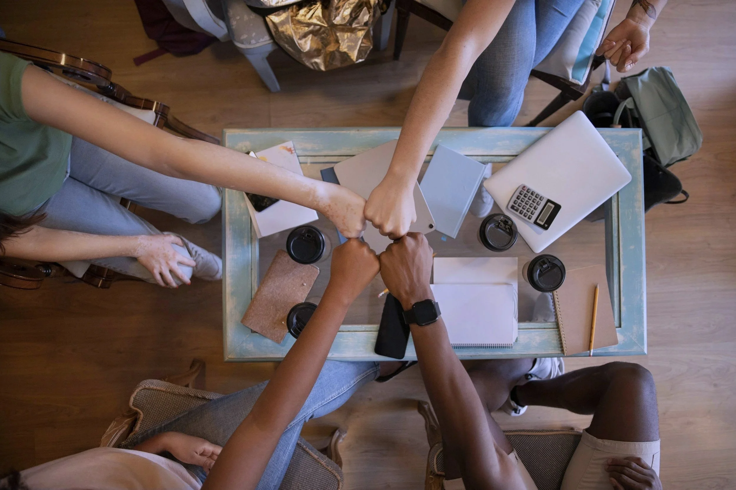 Multiple hands holding and playing with various LEGO action figures in a group setting.