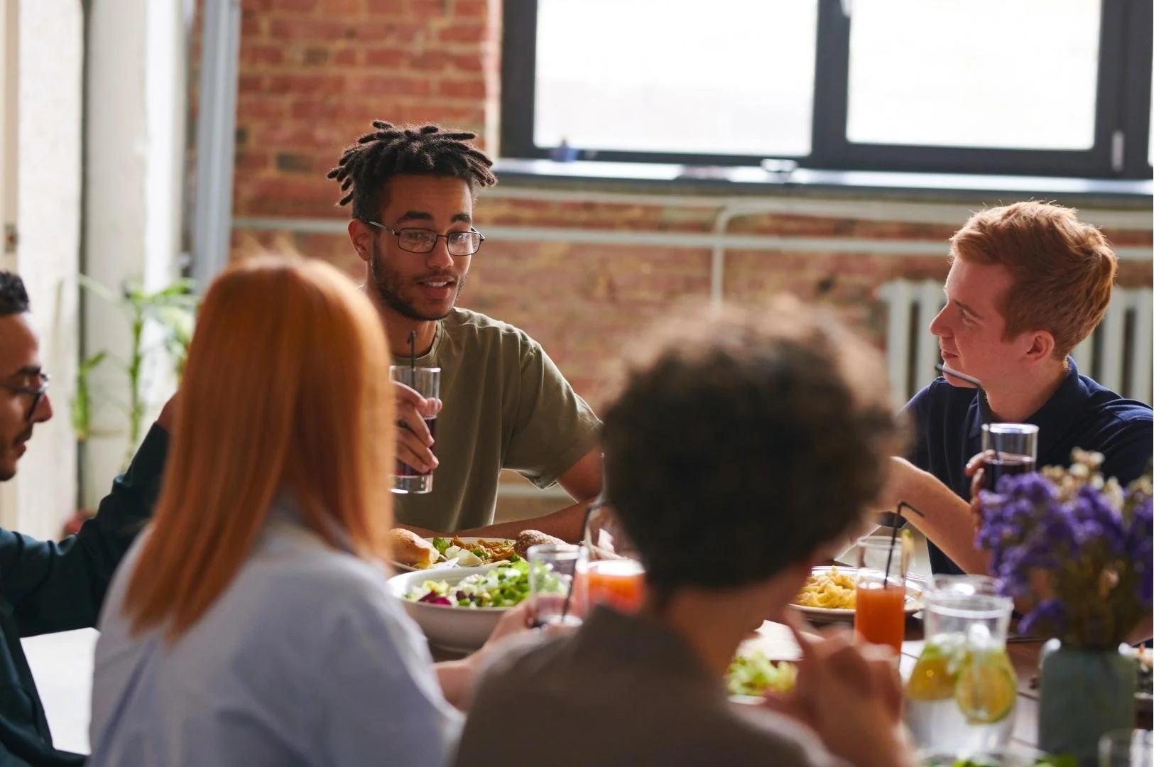 Diverse group of friends enjoying a meal together at Alpha