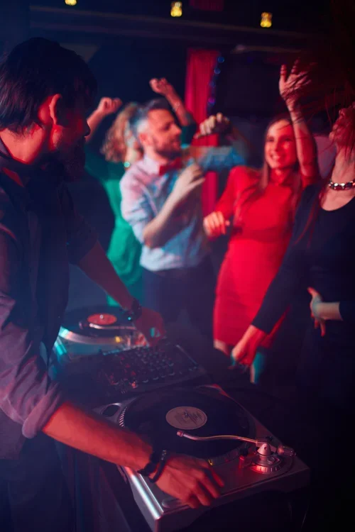 DJ performing at a nightclub or party, operating turntables-College Events