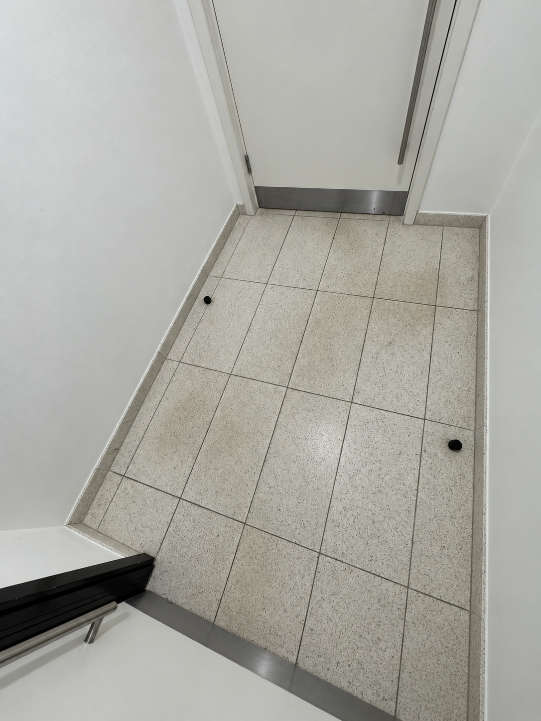 Restored and polished terrazzo floor in a London commercial lobby, showing improved clarity and shine.