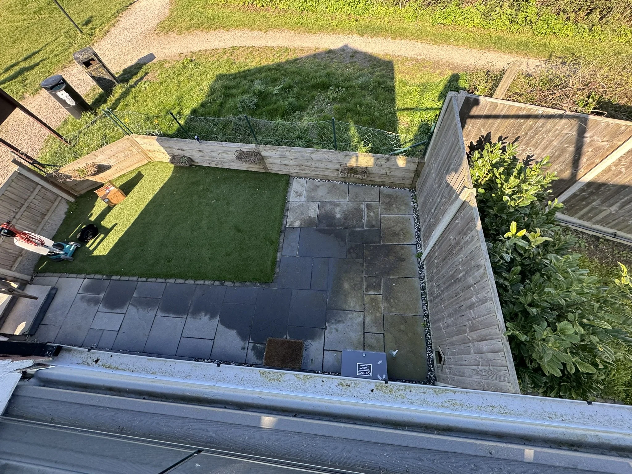 Exterior slate patio during professional restoration, showing the contrast between deep-cleaned stone and the weathered surface before resealing.