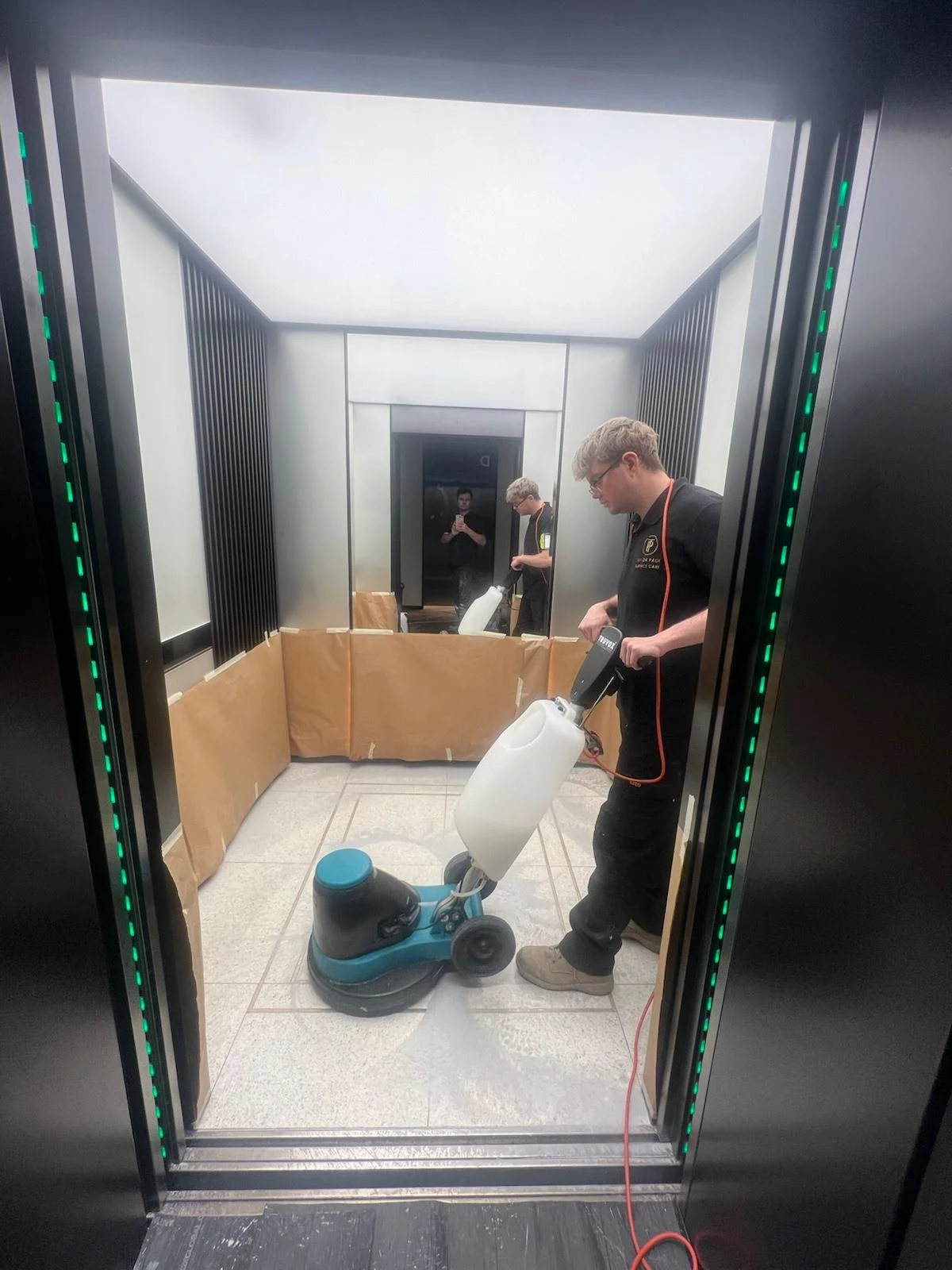 Specialist diamond restoration and polishing of a terrazzo lift floor in a London commercial property, with surrounding surfaces protected during the work.