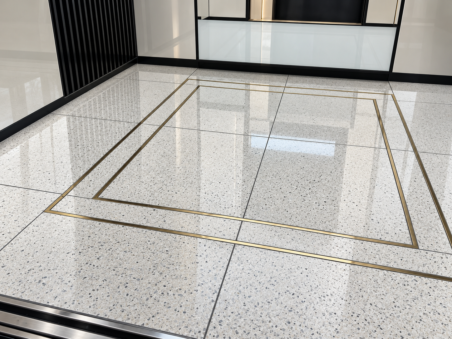 High-shine terrazzo lift floor with brass detailing after specialist restoration and polishing in a London commercial property.