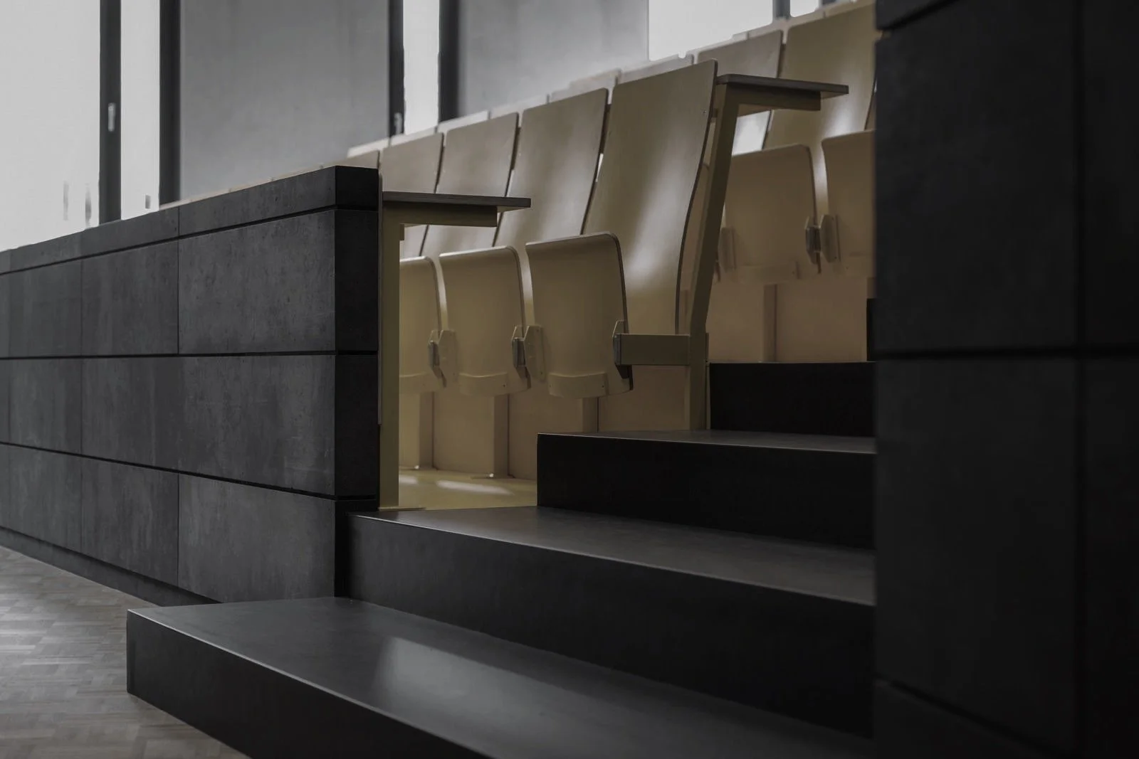 Lage with beige seats in an auditorium or lecture hall, viewed from a side angle.