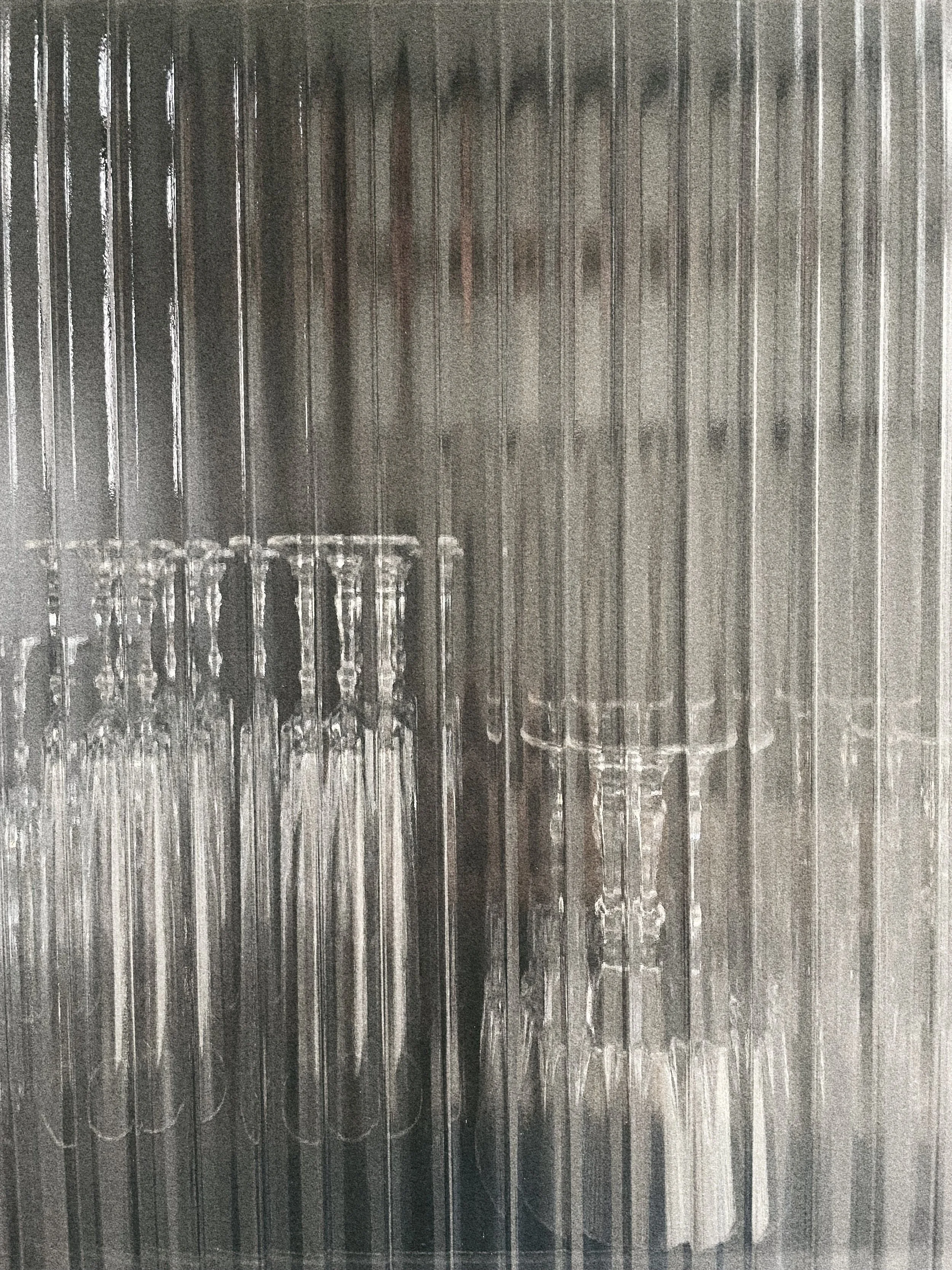 Glazen testbuizen en meetbekers staan op een tafel of werkblad, de achtergrond is een kast of muur met een metallic of glazen oppervlak.