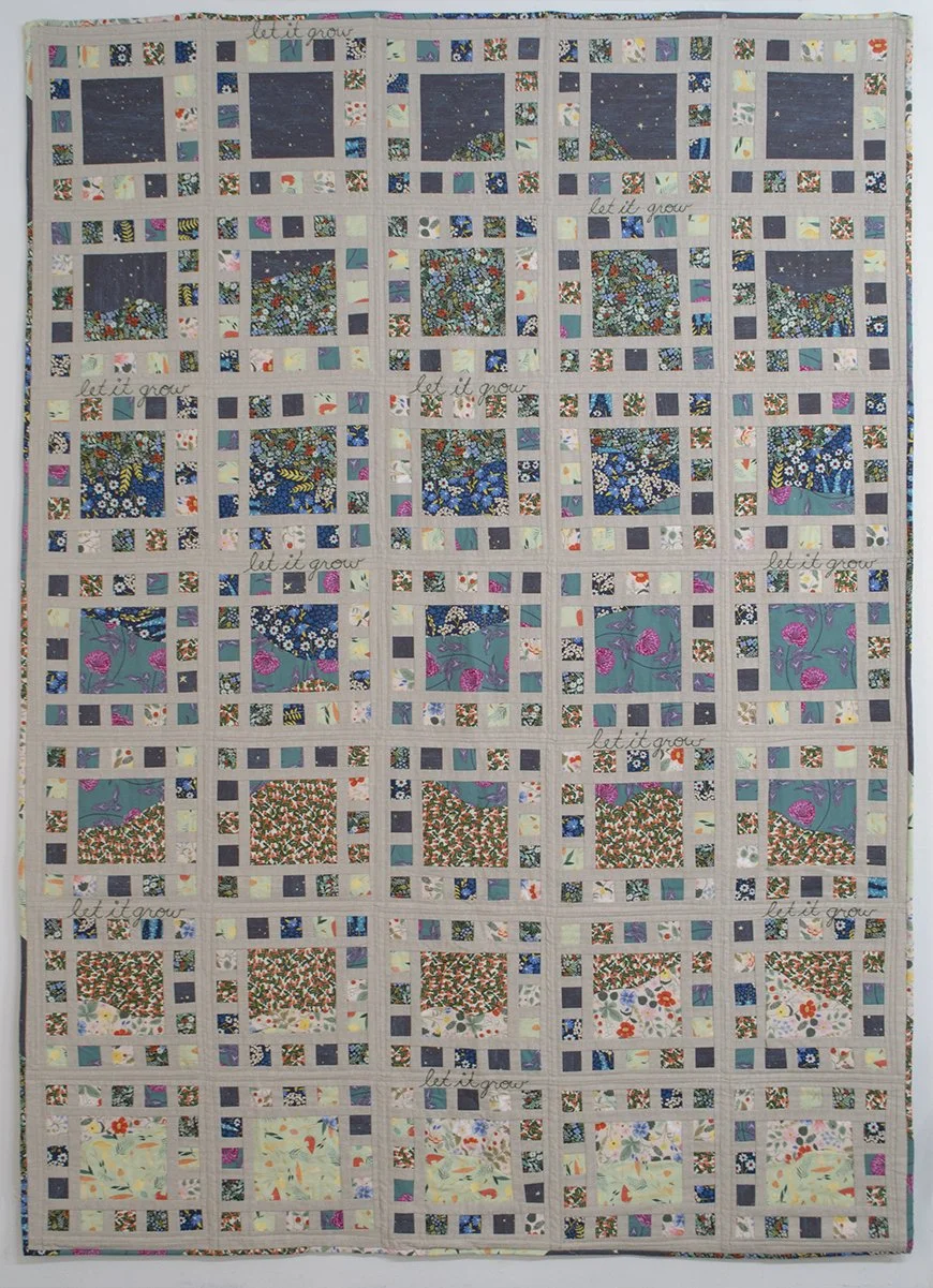 Quilt with many colorful squares with floral fabrics and the embroidered words "let it grow"