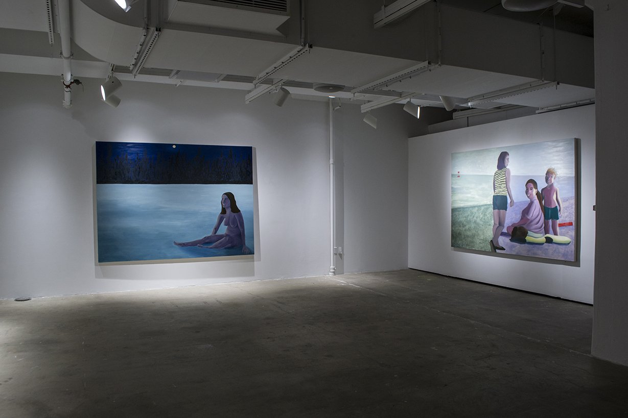 Art show with painting of naked woman and another painting of three people on beach