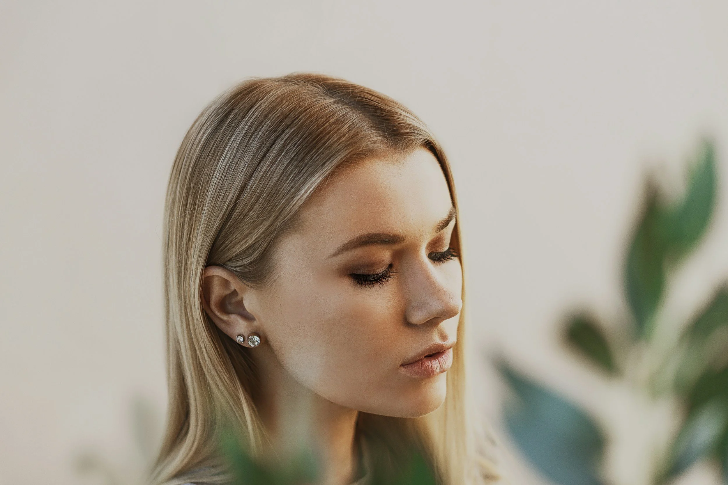 Side profile of a woman with closed eyes, wearing earrings.