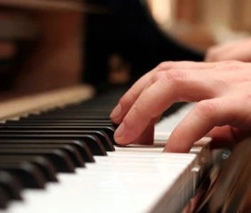 Hands resting on piano keys