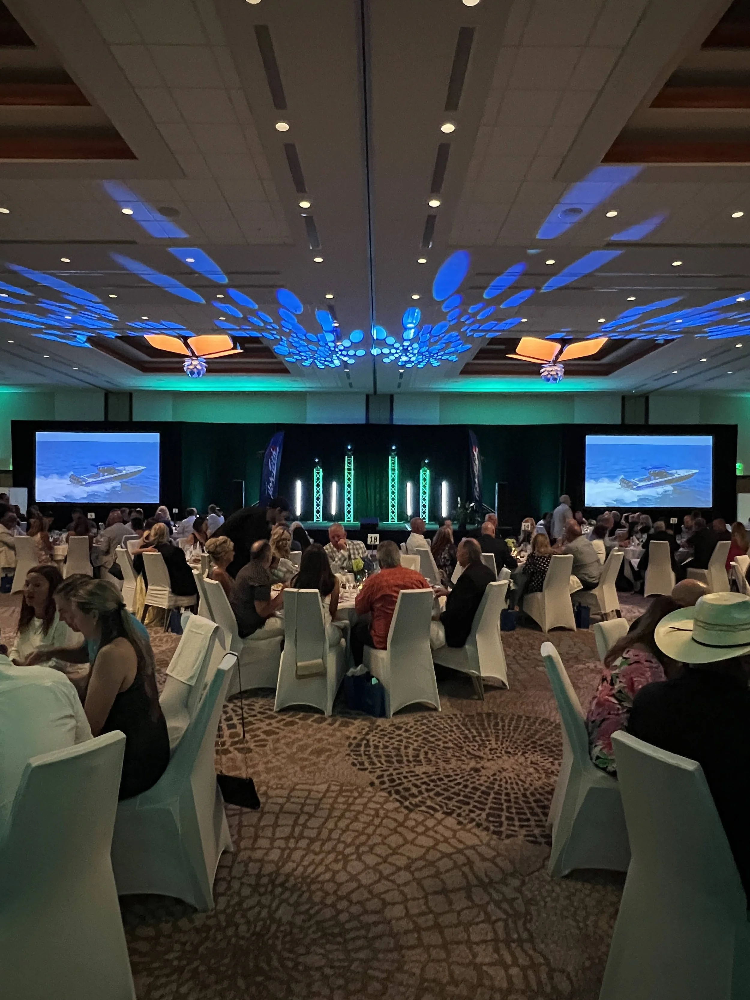 Ballroom setup with dual screens and ambient lighting for a corporate event in Sarasota