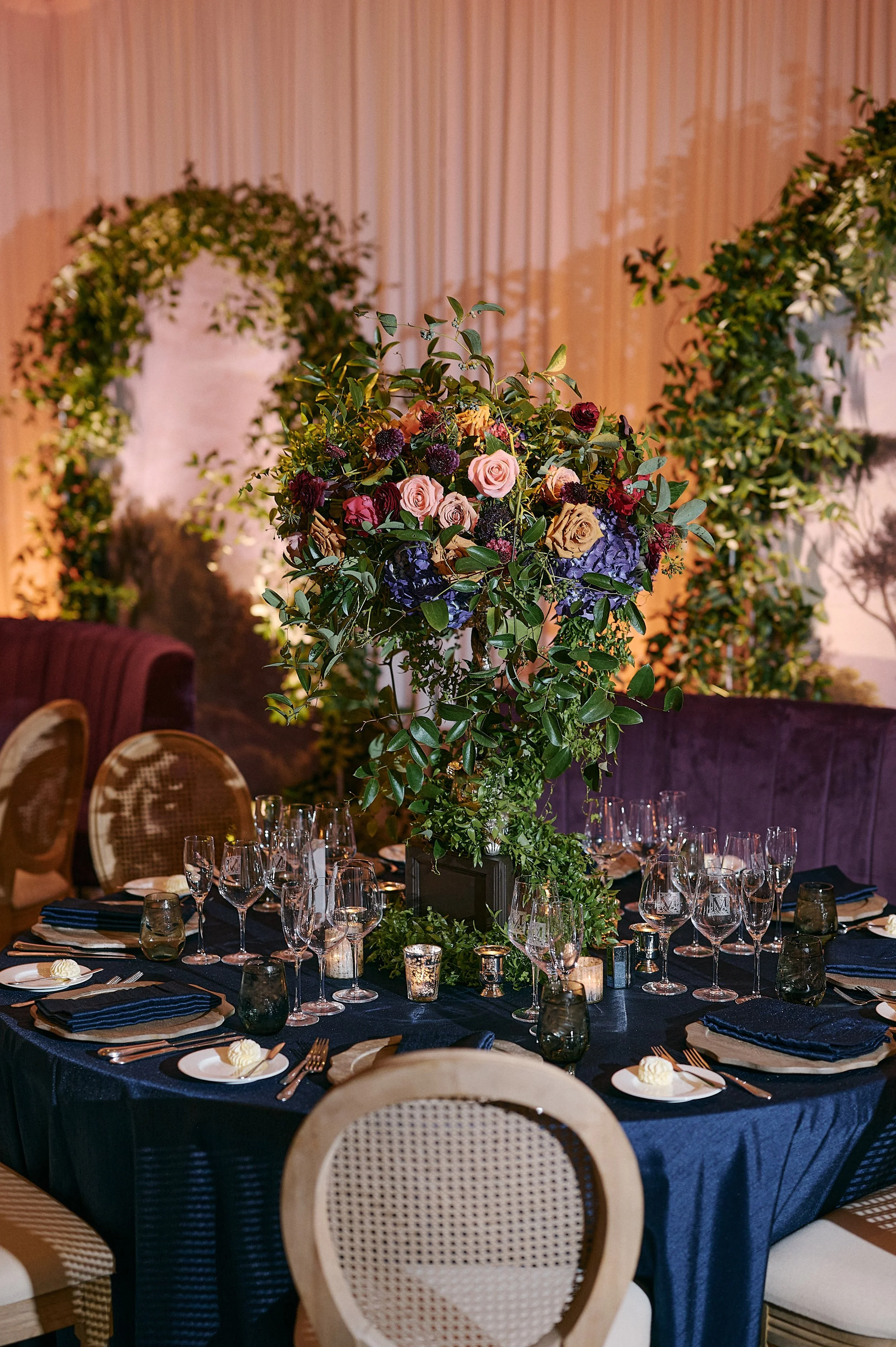 Tall floral arrangement with greenery arch backdrop in Southwest Florida