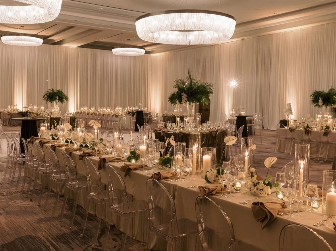 Ballroom with white drapery, chandeliers, and a candlelit long table in Southwest Florida