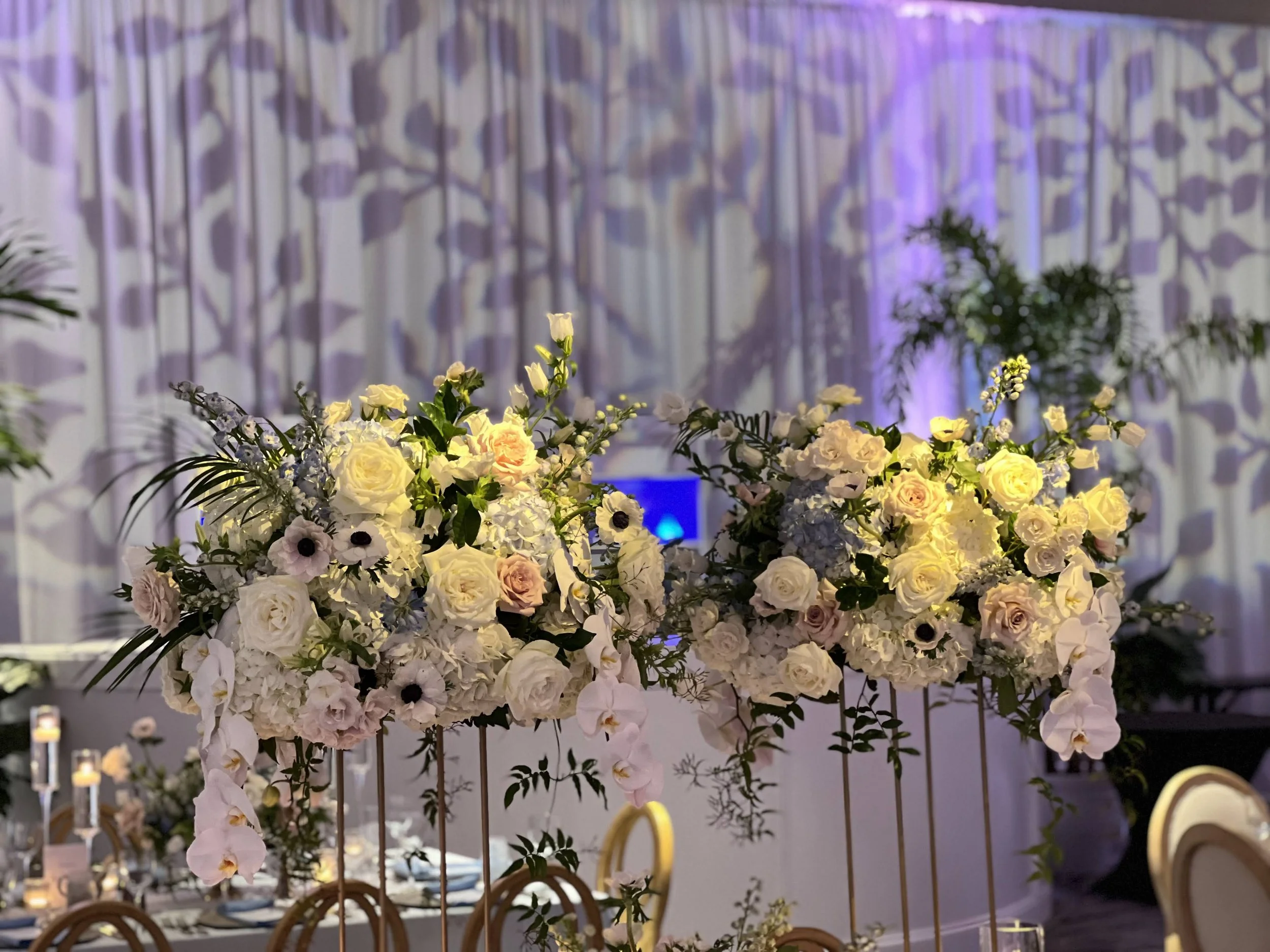 Floral arrangement with gobo pattern lighting on drapery backdrop in Sarasota