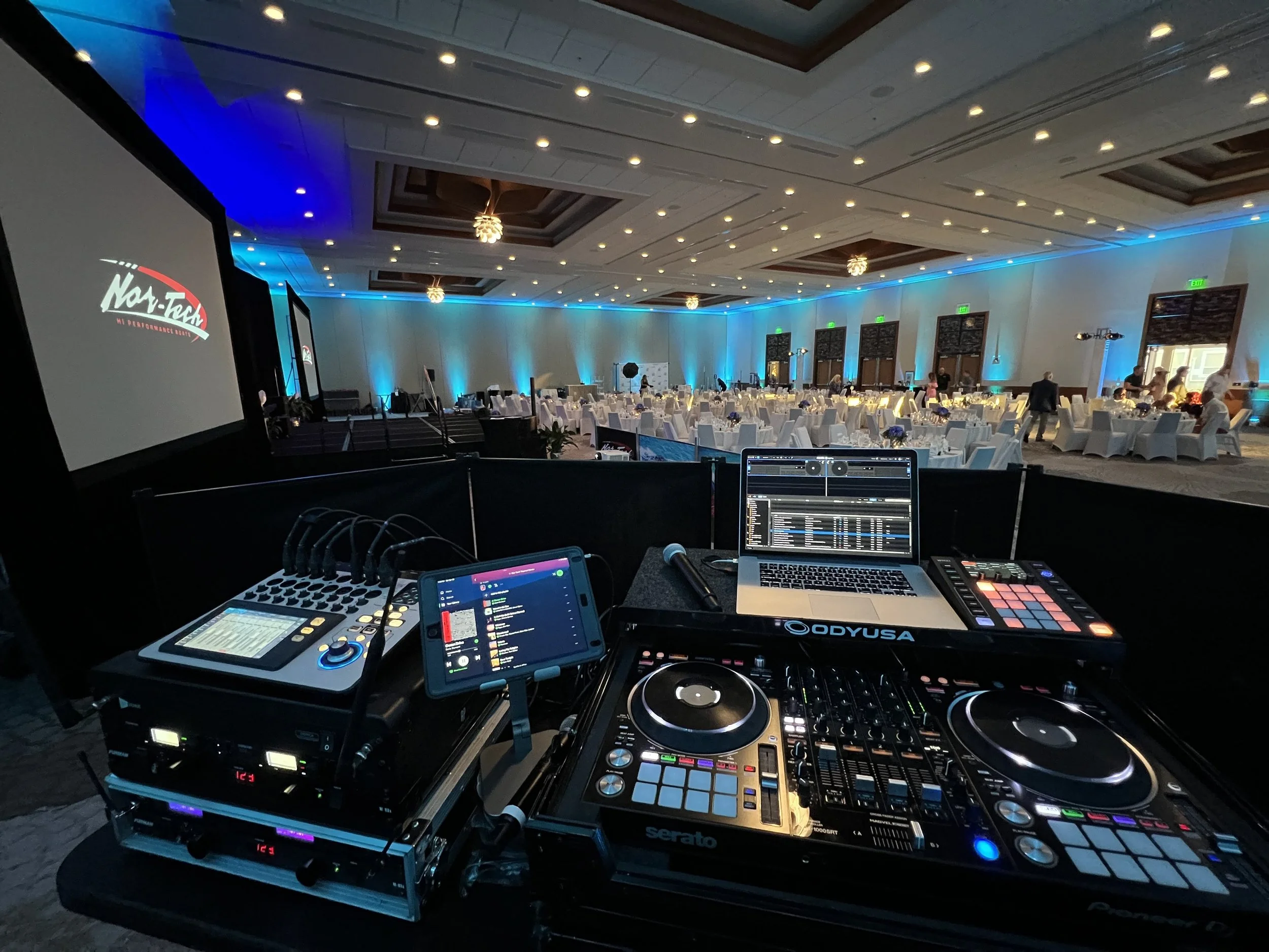 DJ equipment and mixing setup with branded event signage in Sarasota