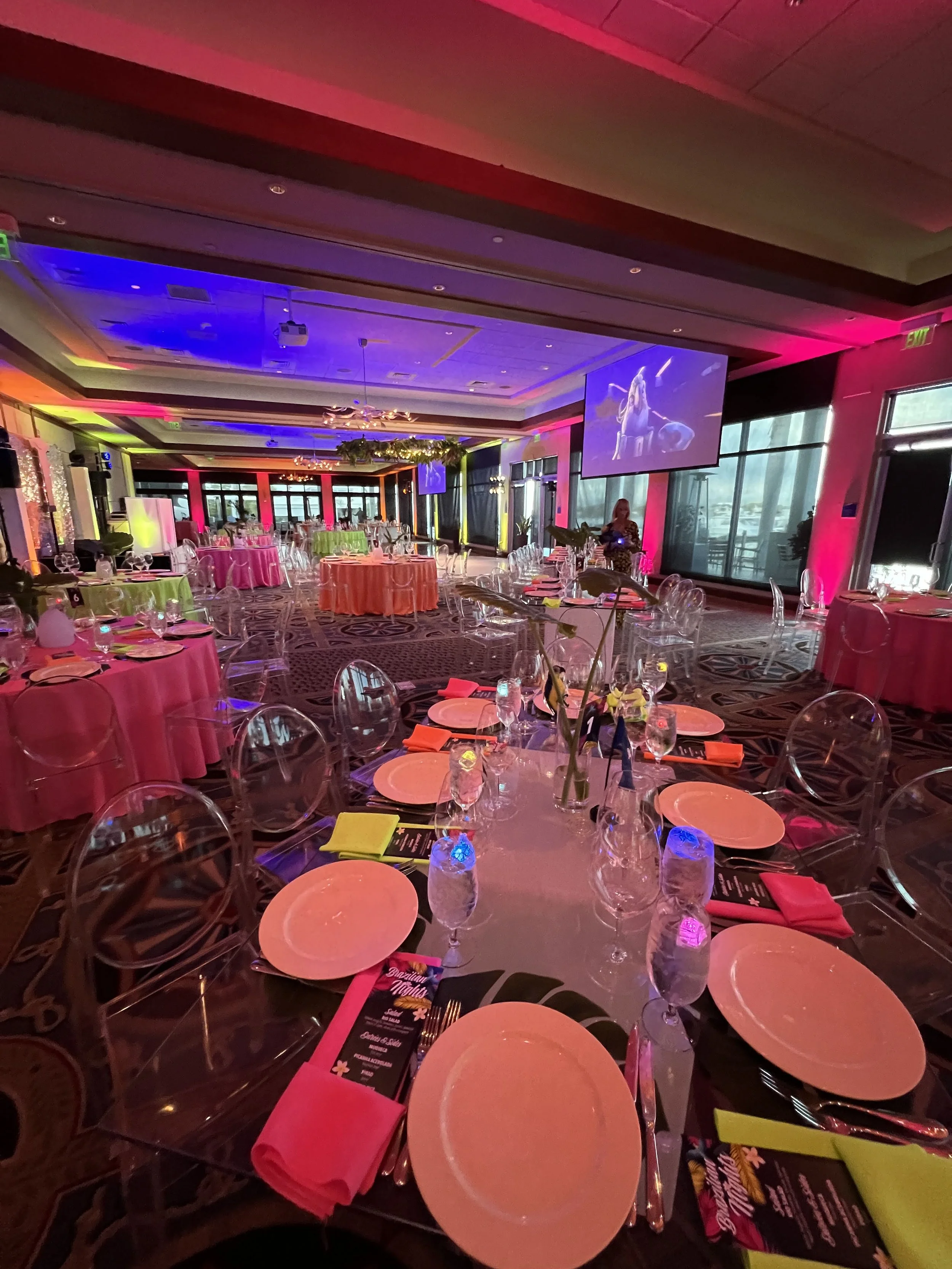 Ballroom with pink, orange, and green ambient lighting for a colorful event in Southwest Florida
