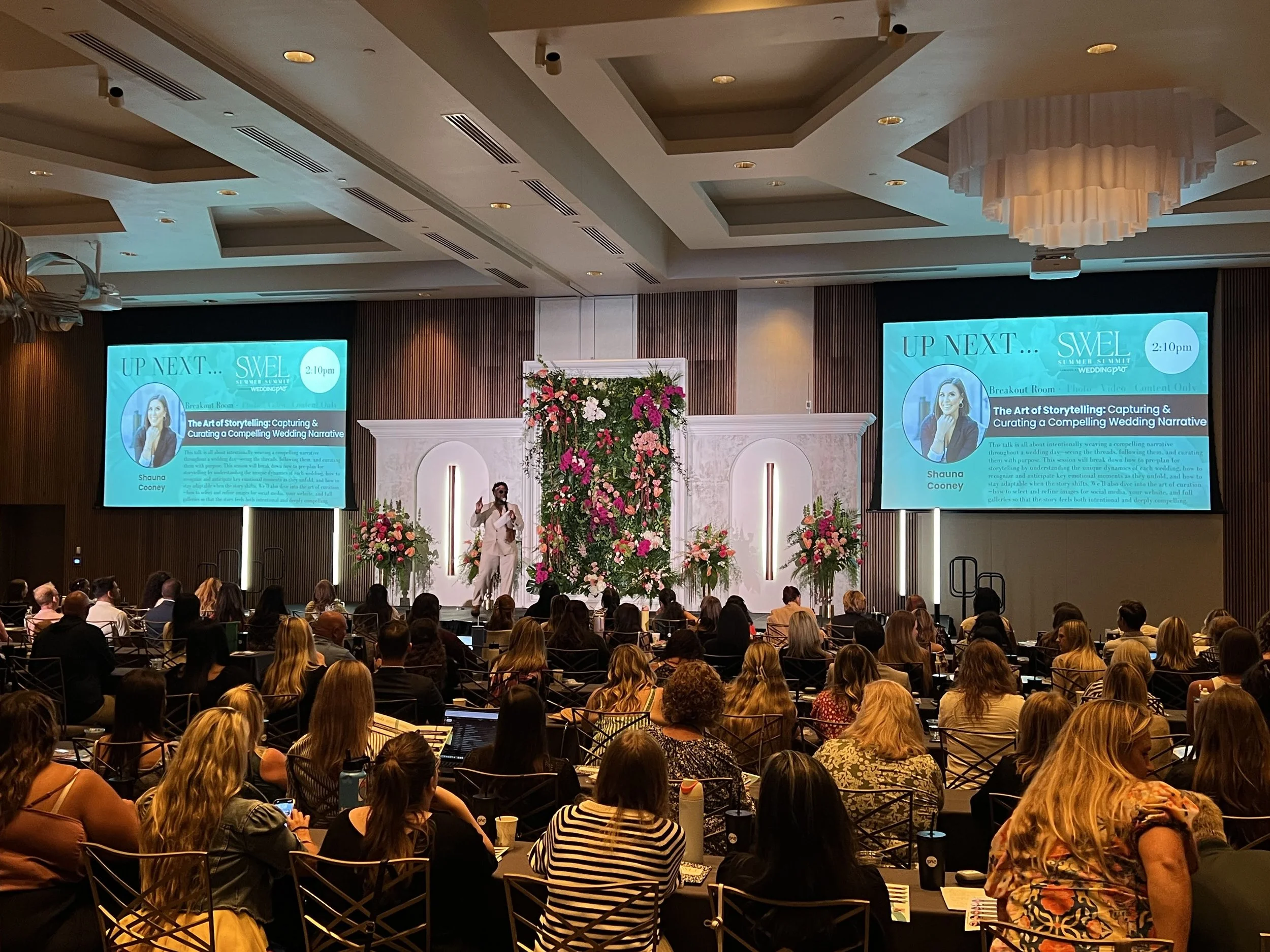 Dual projection screens and stage setup for a corporate conference audience, event production in Sarasota