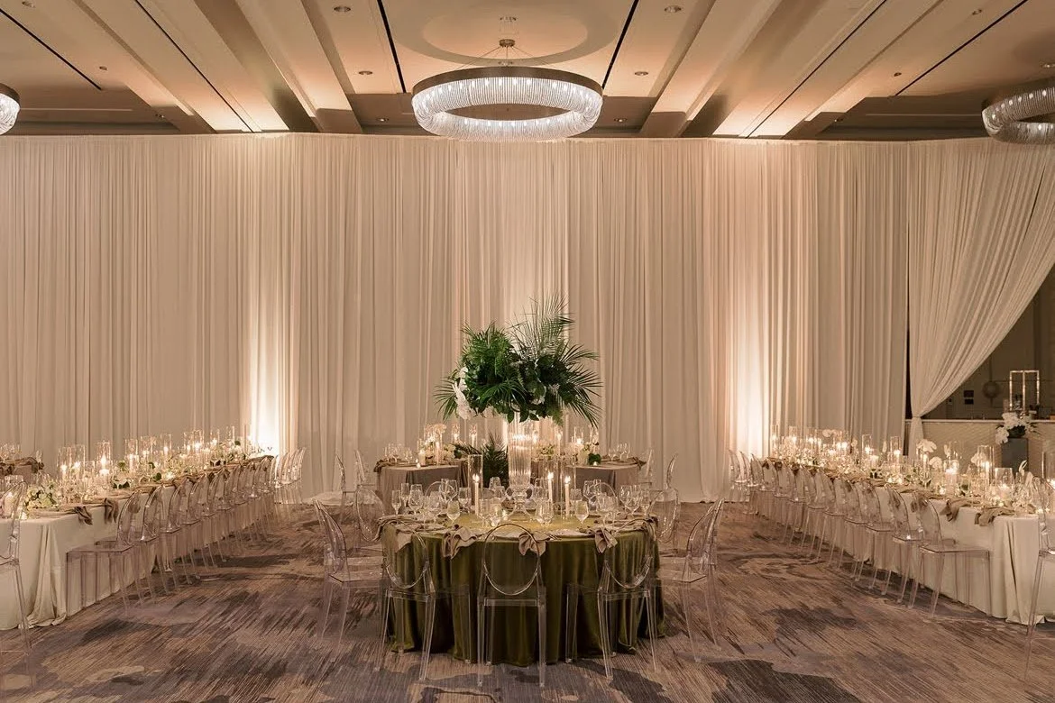 Ballroom with white drapery and round tables set for an event in Sarasota