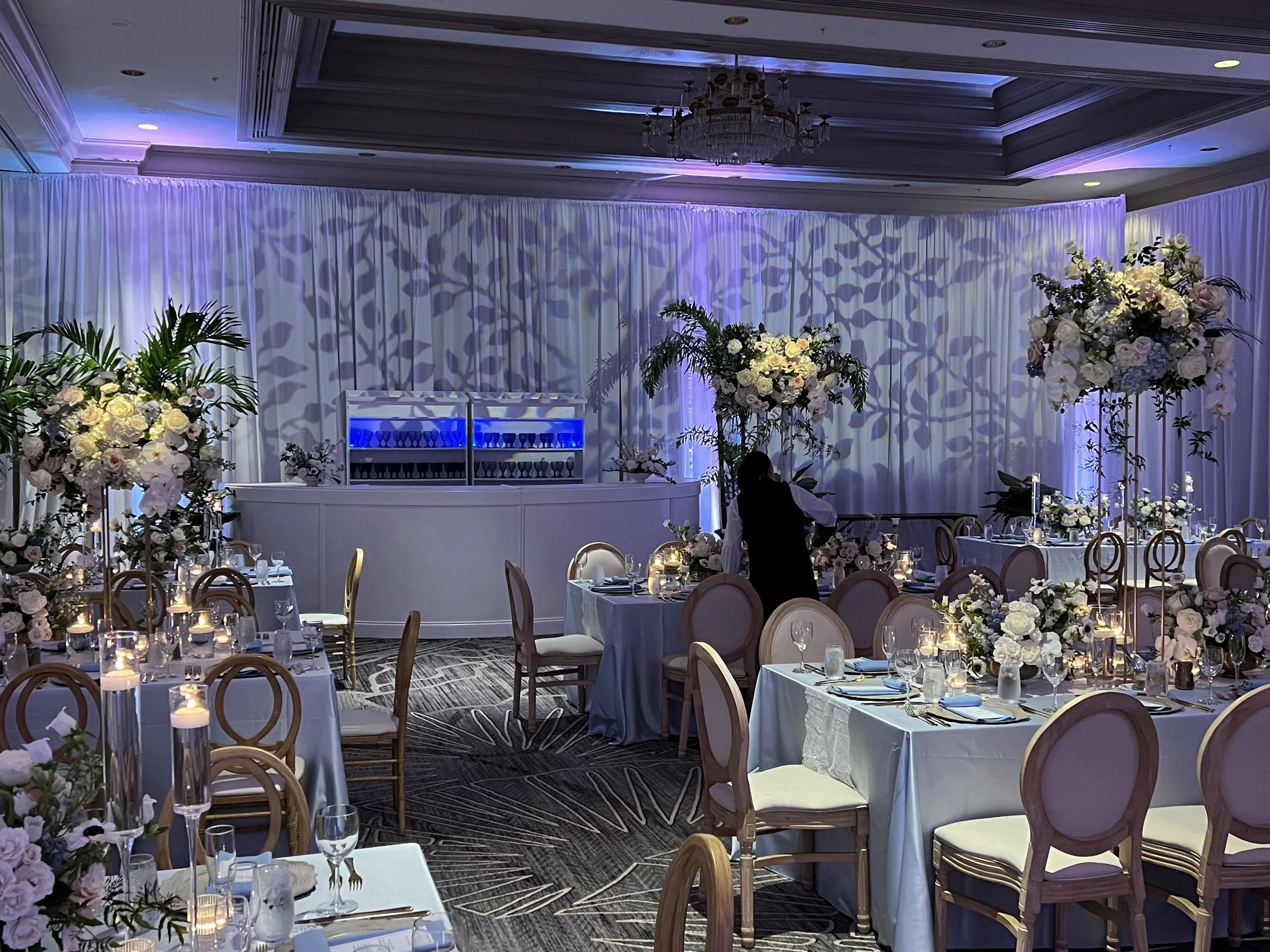 Floral pattern gobo projection on grey drapery with tall floral centerpieces in Southwest Florida