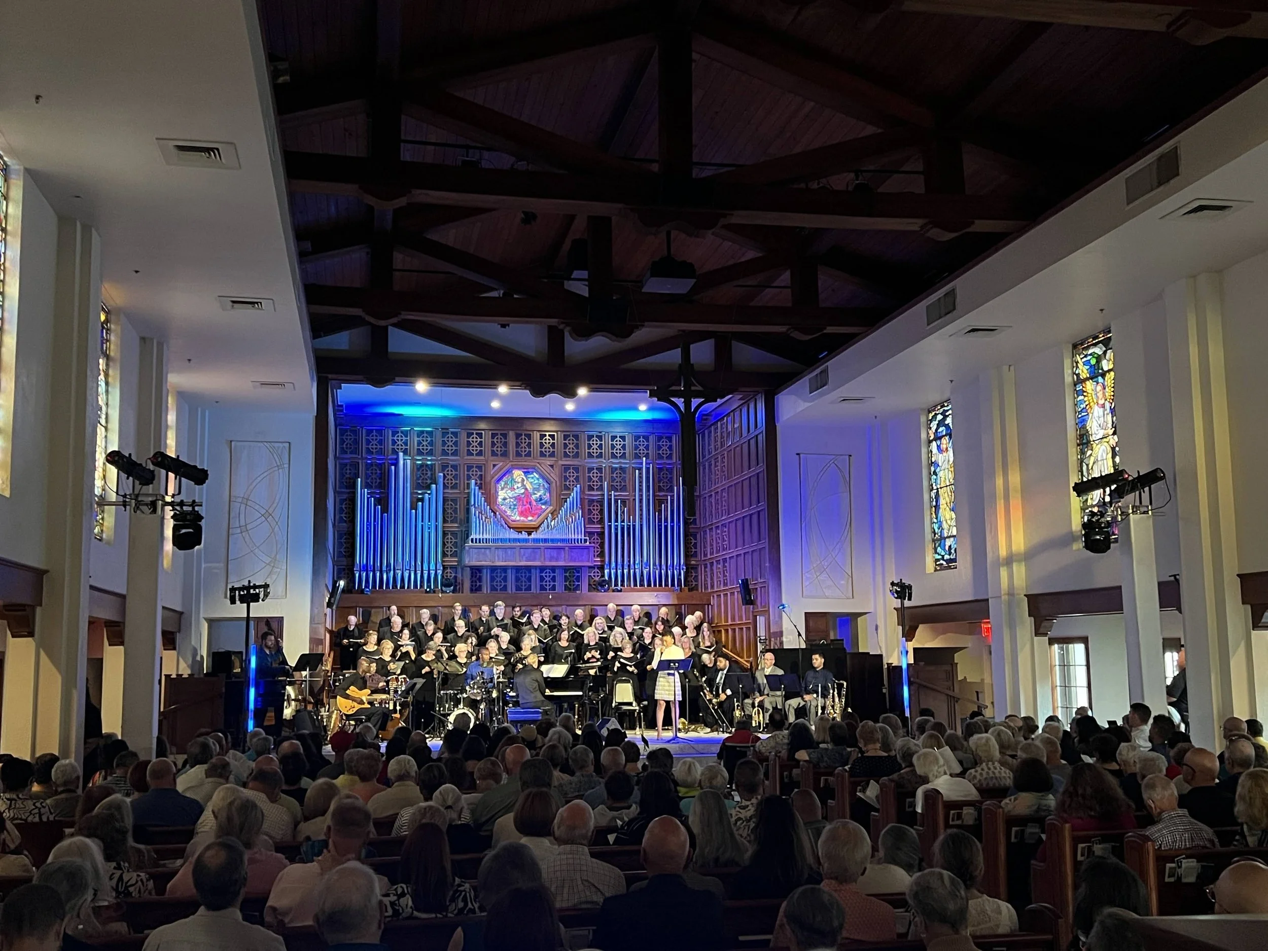 Church choir performance with blue stage lighting on organ pipes in Sarasota