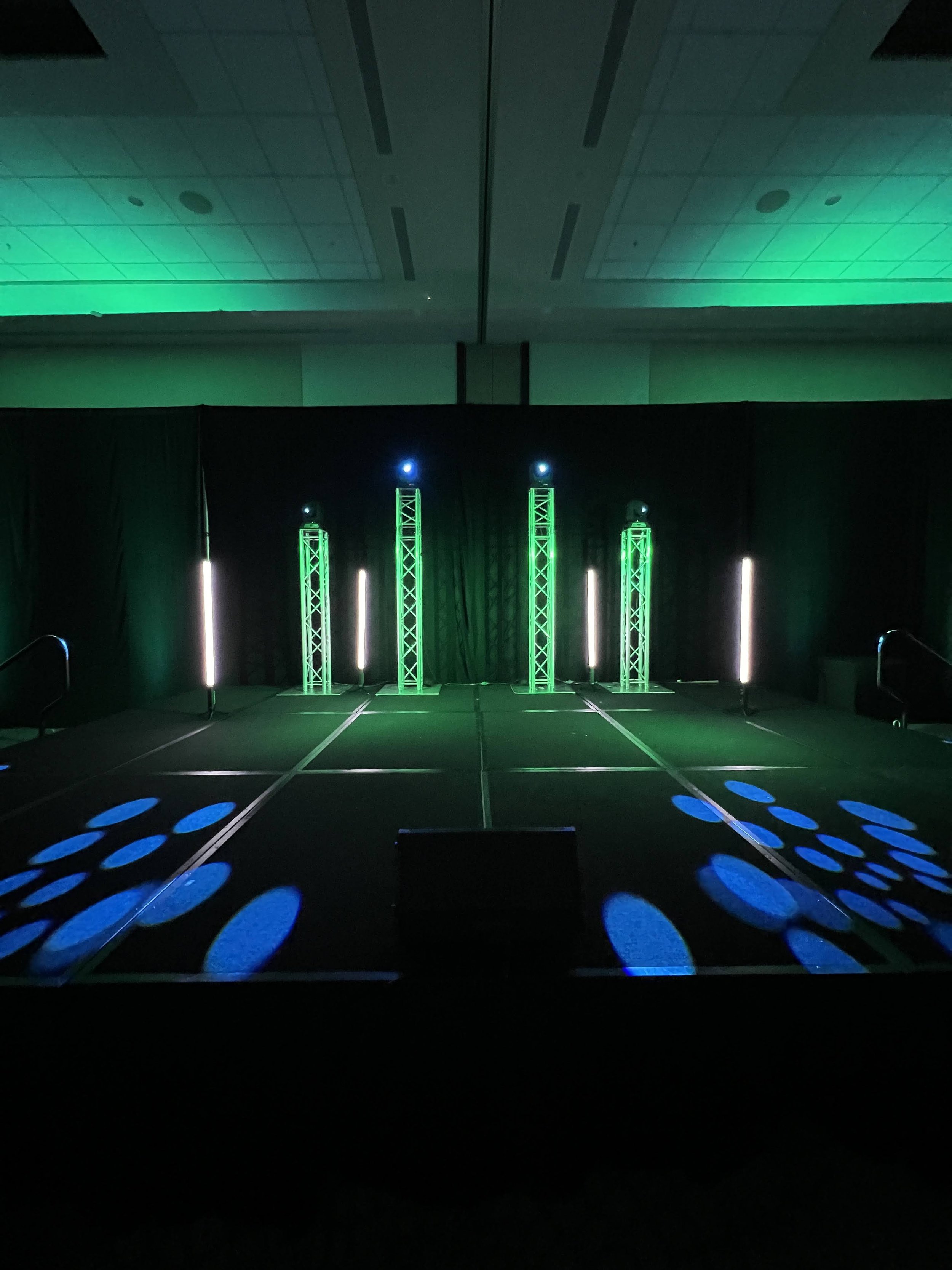 Green-lit truss towers with polka dot gobo pattern on the floor in Southwest Florida