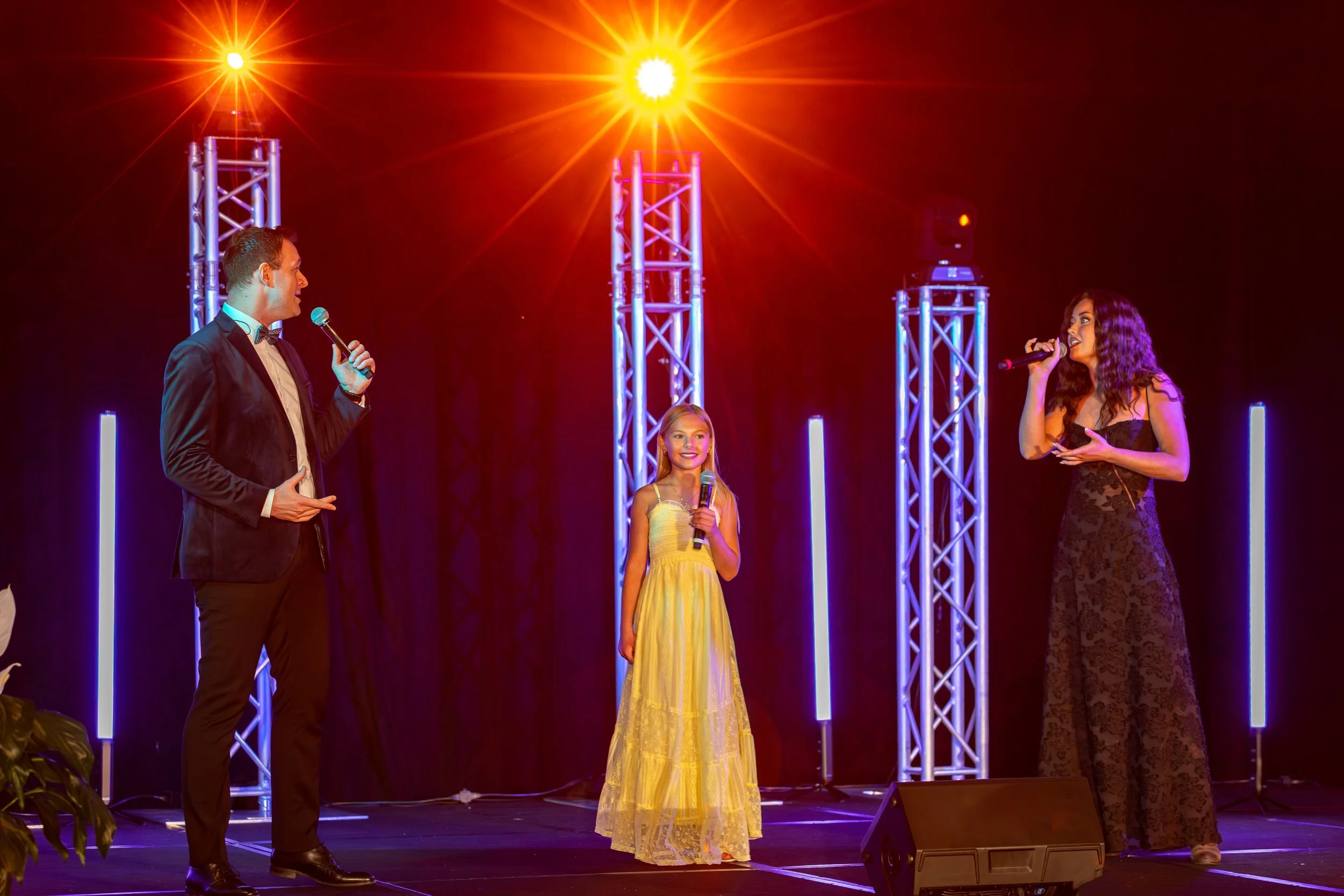 Performers on stage with red and purple truss lighting towers in Southwest Florida