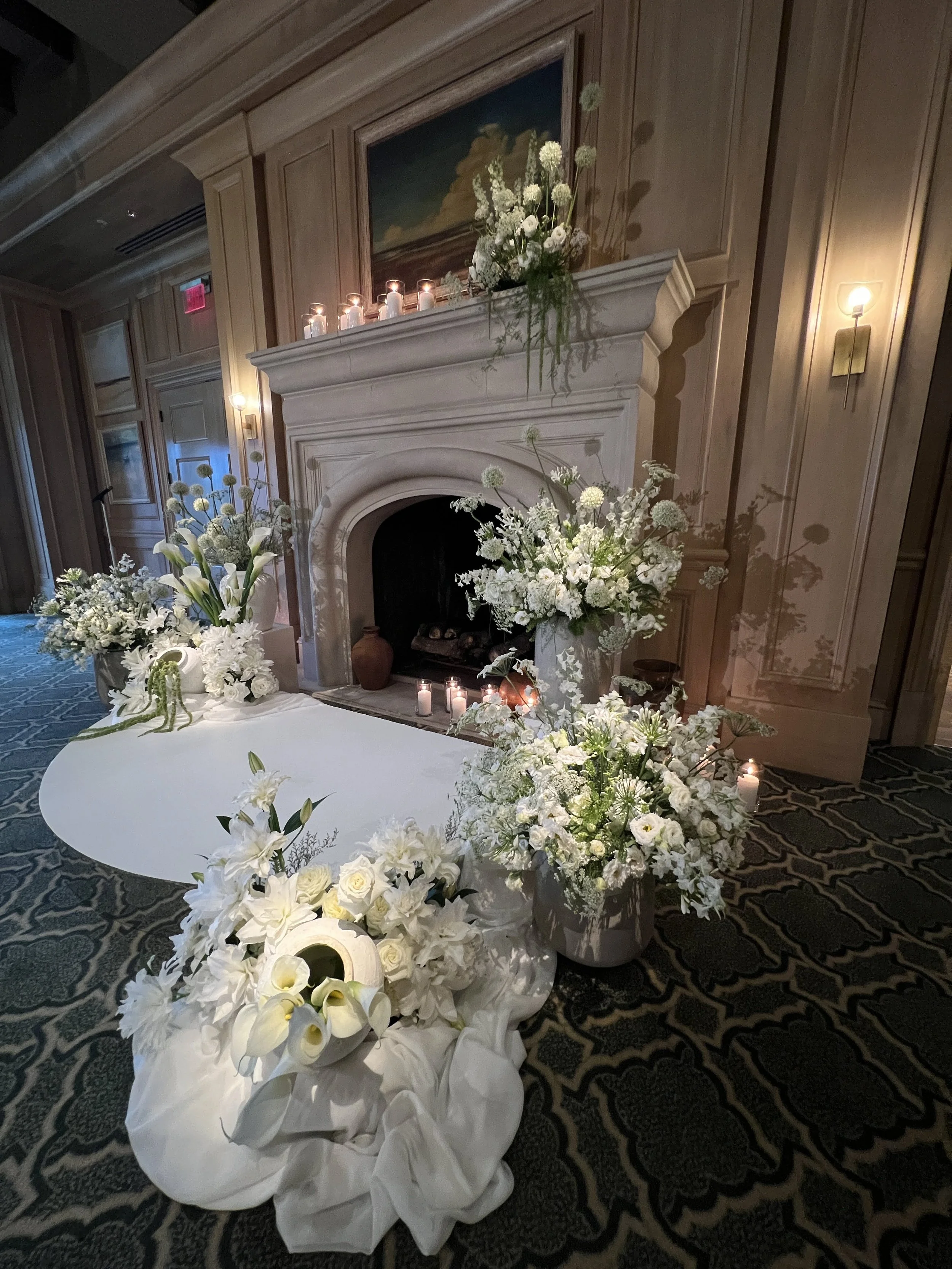 White floral arrangement at a stone fireplace mantel in Sarasota
