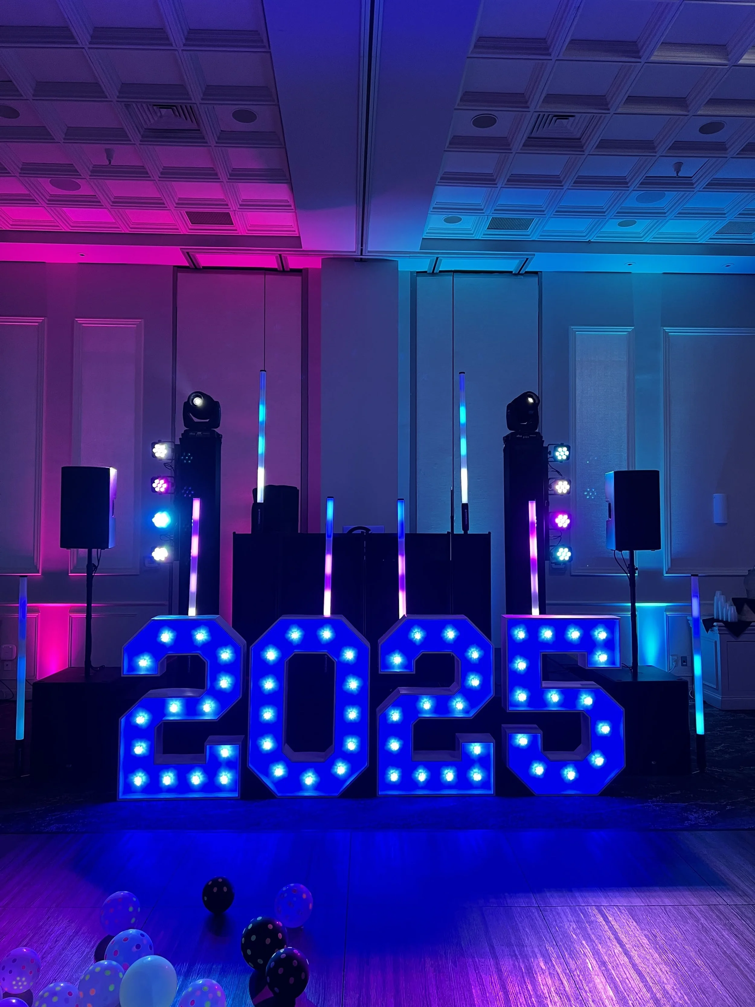 DJ setup with blue and pink lighting and lit marquee numbers in Sarasota