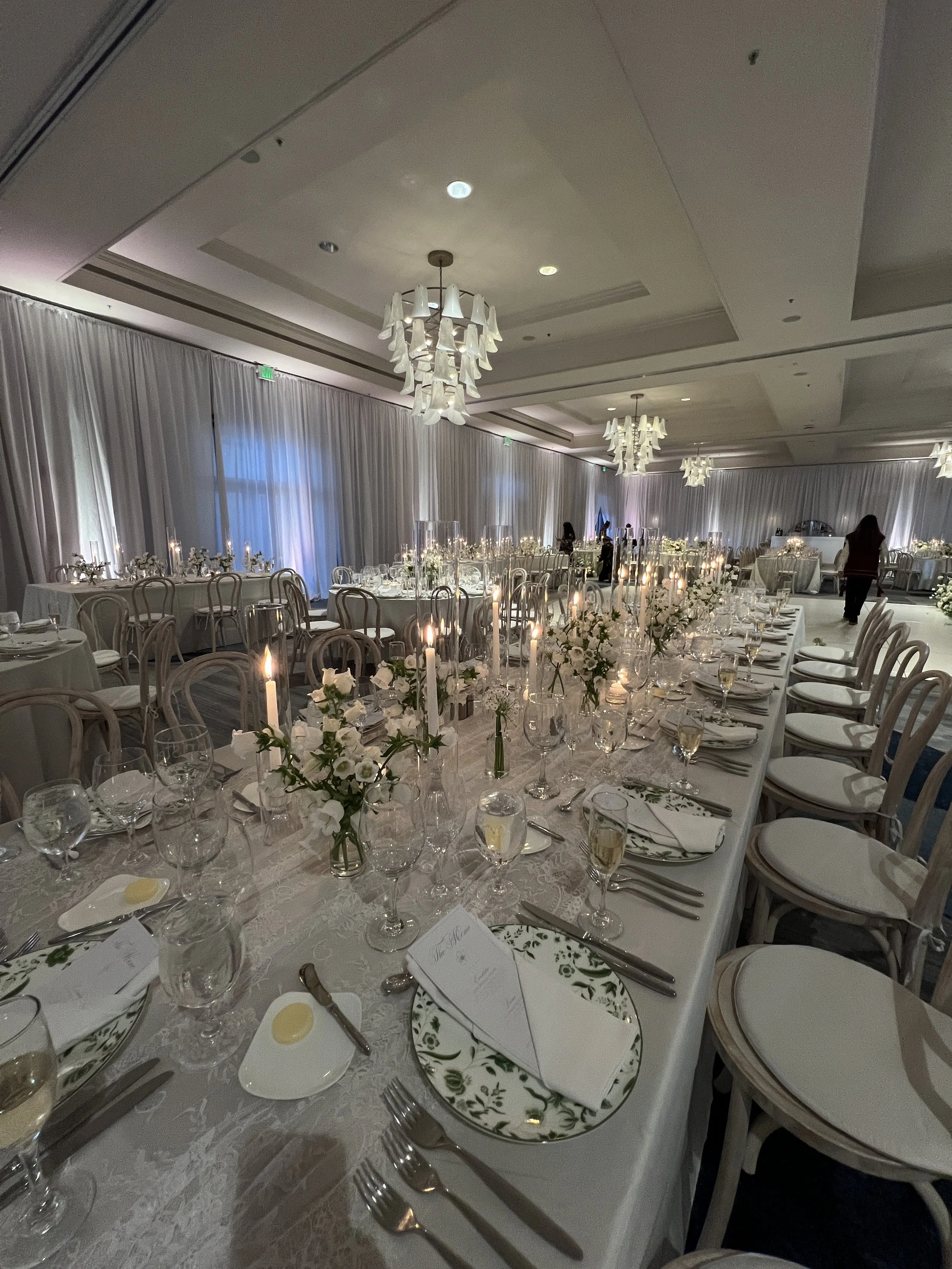 Ballroom with white drapery and a candlelit long table setting in Southwest Florida