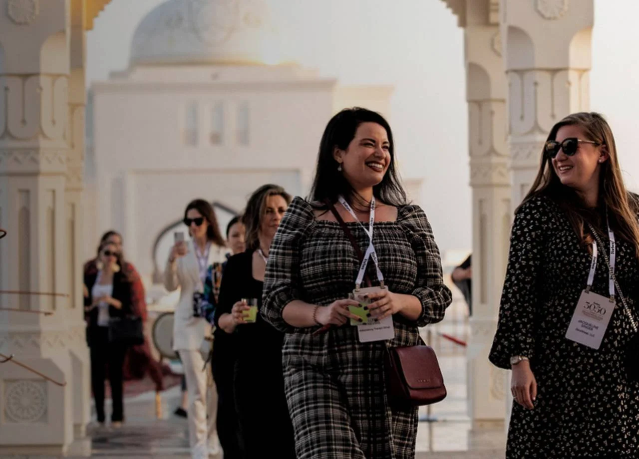 Forbes 30/50 Summit attendees walk through a white archway in Abu Dhabi.