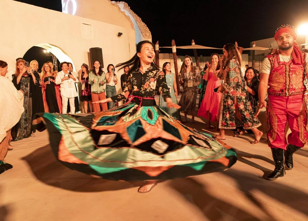 An attendee twirls in a colorful tanoura skirt during a nighttime dance at the Forbes 30/50 Summit in Abu Dhabi.