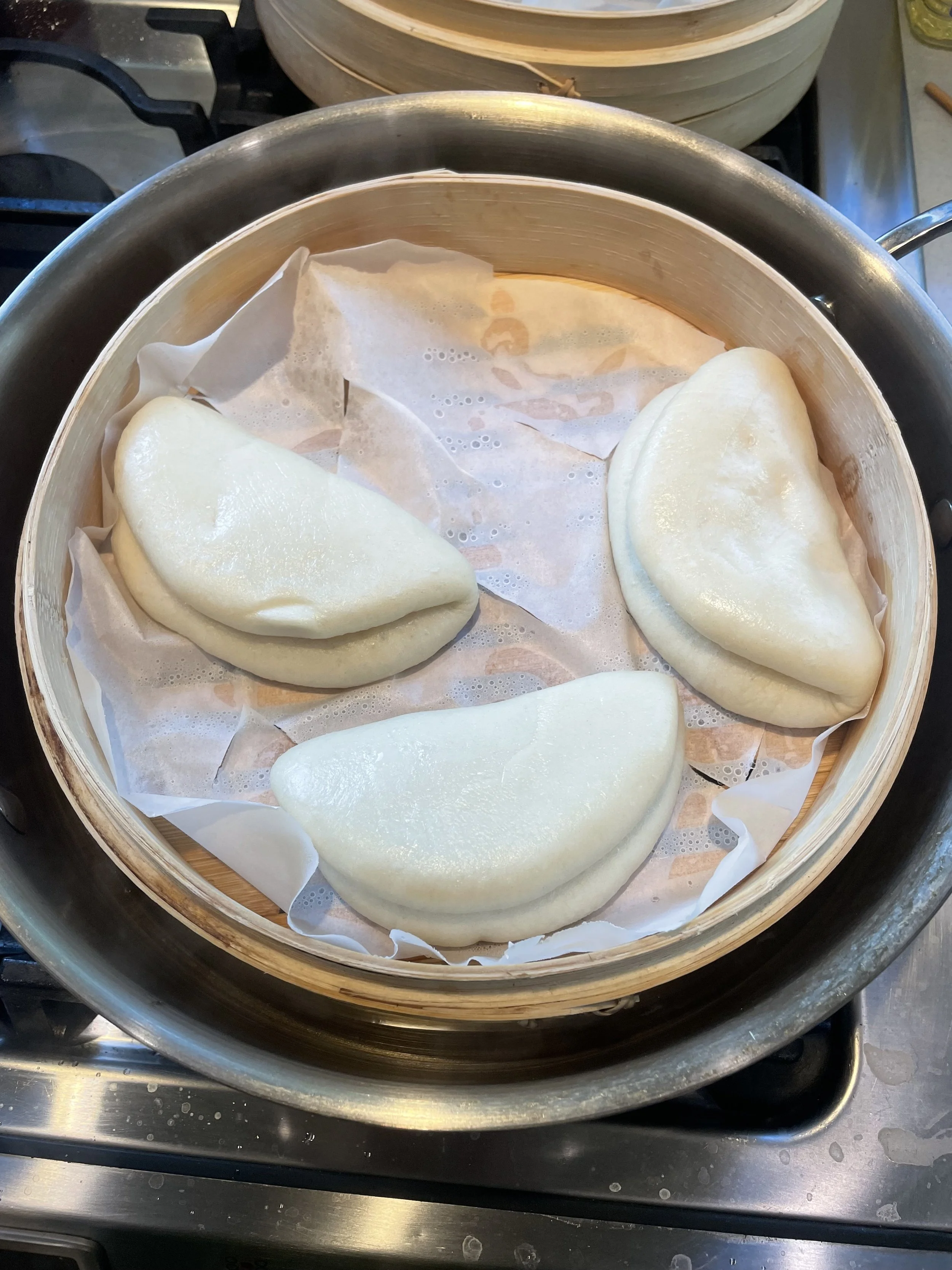 Steamed bao buns in a bamboo steamer, a private chef appetizer for a Revelstoke ski holiday.