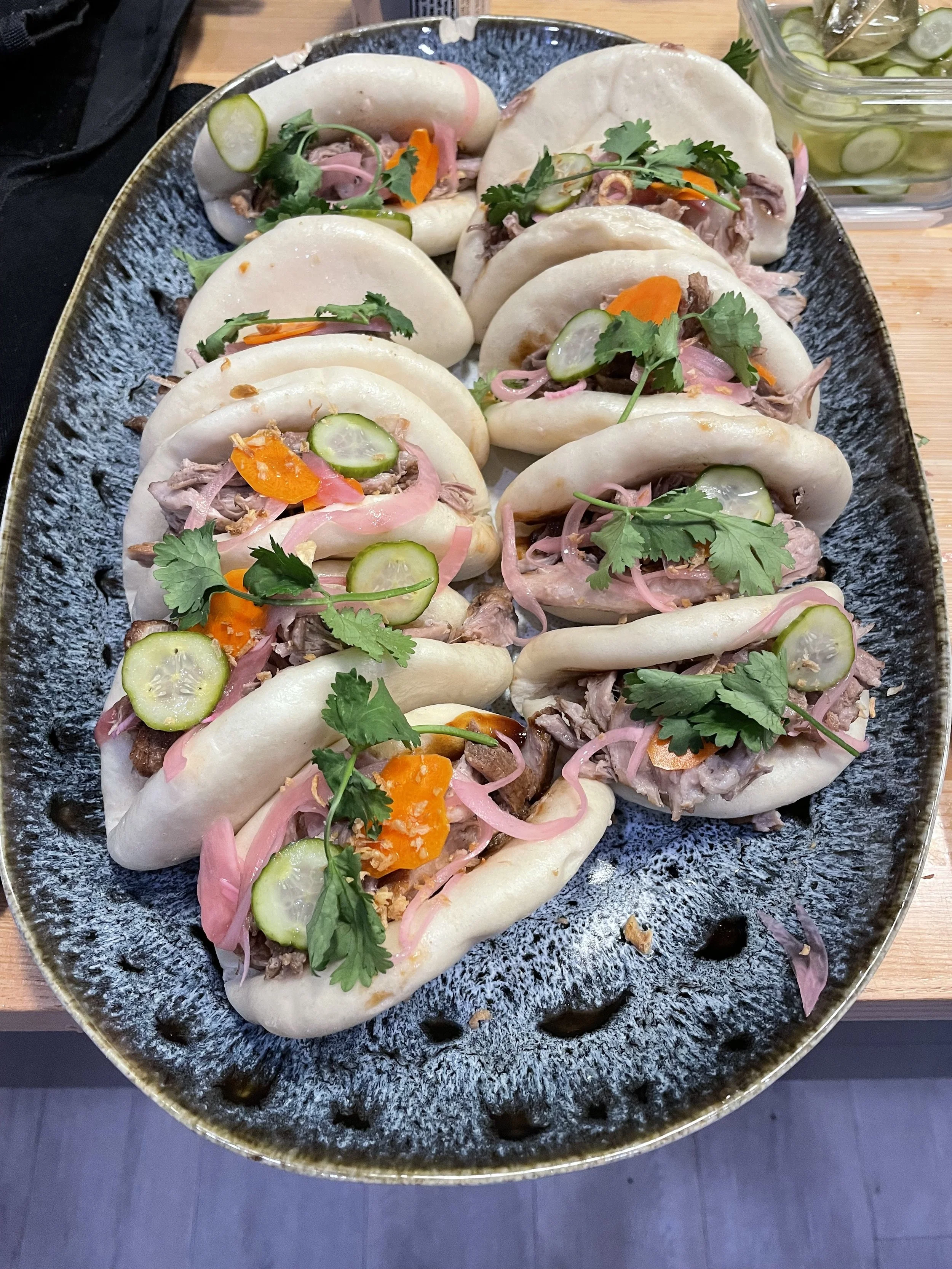 Pork belly bao buns with pickled cucumber, carrot and cilantro, catered for a Revelstoke ski lodge group.