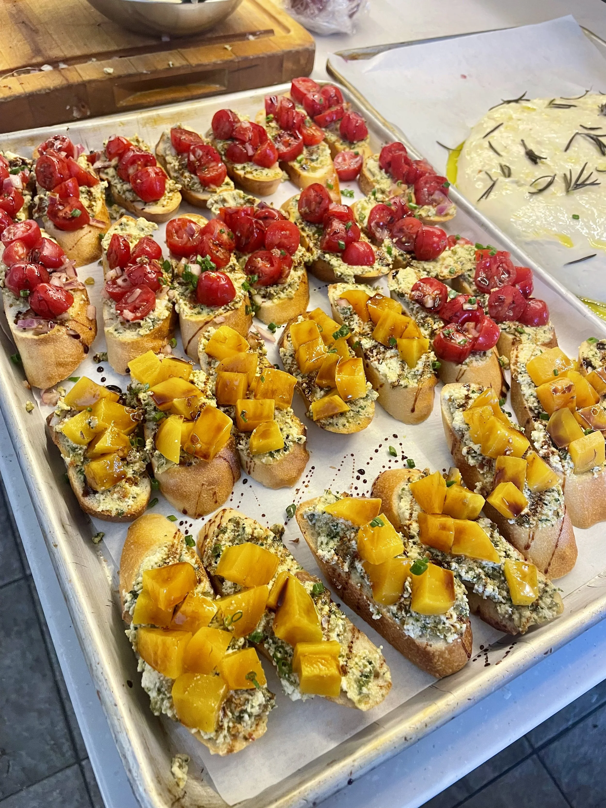 Crostini with herbed cheese, golden peppers and tomato, party appetizers by a Revelstoke catering chef.