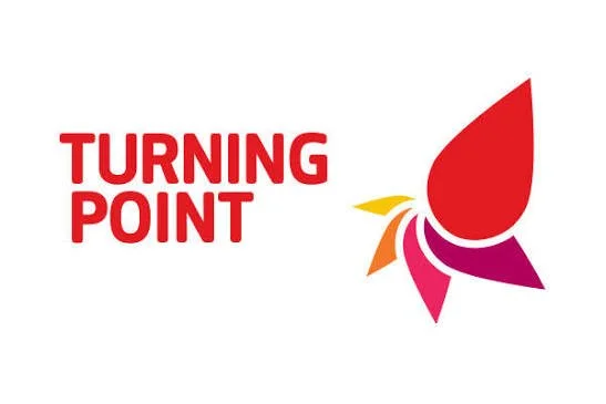 Logo with the words 'Turning Point' in red text and a stylized, multicolored abstract flower or butterfly on the right.