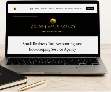 Laptop displaying the Golden Apple Agency website, a tax and accounting service for small businesses, with a notebook and pen beside it.