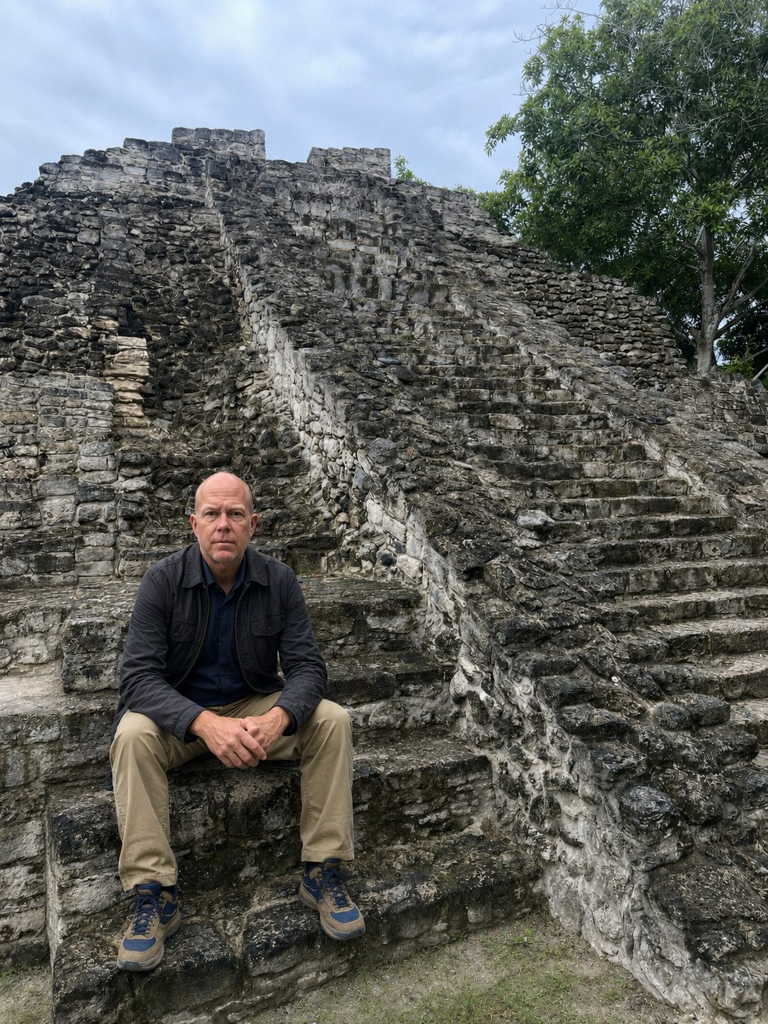 Christopher Gardner seated in front of a Maya pyramid