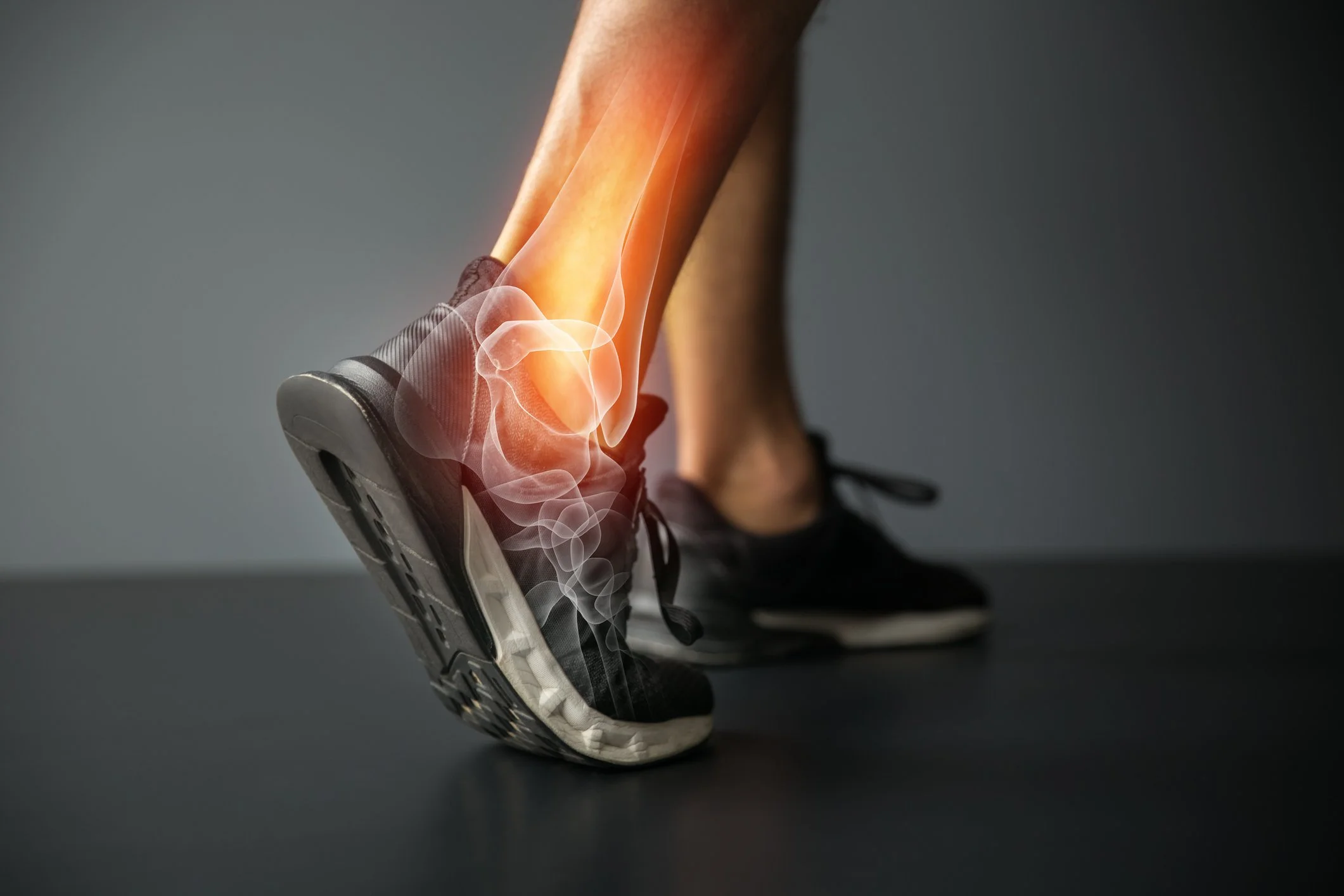 Close-up of a running shoe with a digital overlay showing a transparent skeletal structure of a foot and ankle, highlighting the joints and bones.