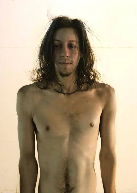 Nicky by Daniel Sprick. Realistic painting of a shirtless young man with long, messy hair standing against a plain background.