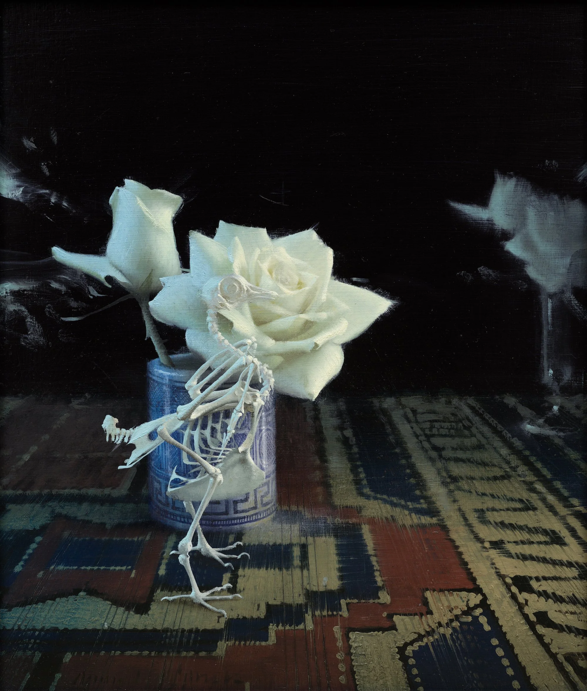 Bird, Skeleton, and Flower by Daniel Sprick. Still life painting of a bird skeleton in front of a blue and white patterned vase with white roses atop a Persian rug. 