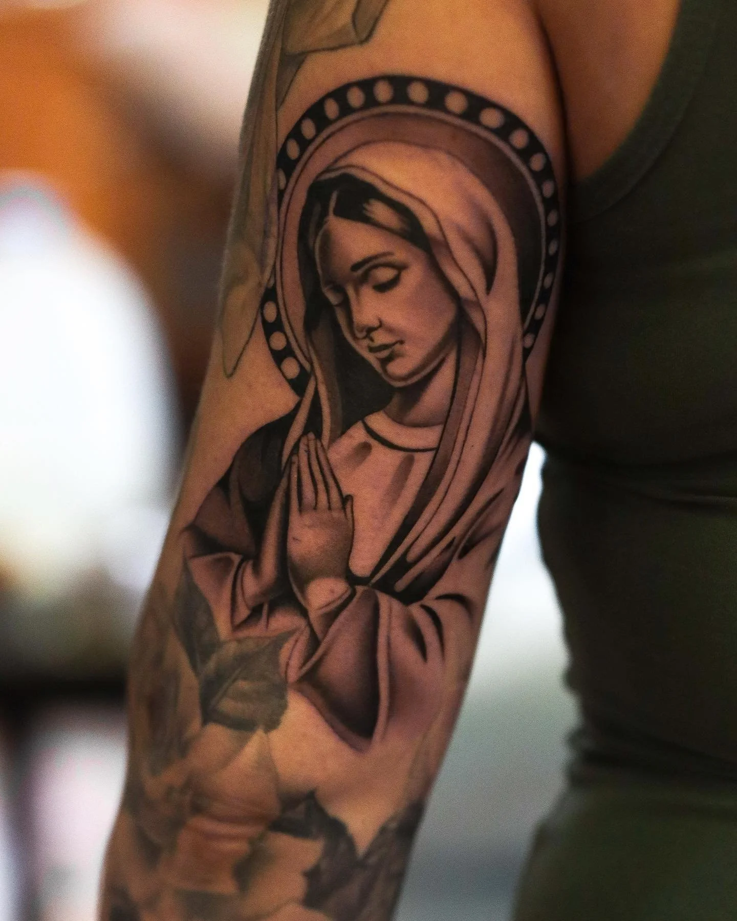Tattoo of the Virgin Mary on a person's upper arm.