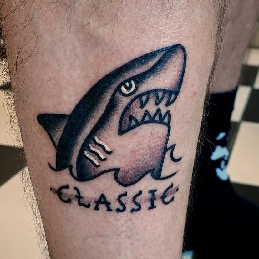 Tattoo of a shark's head with the word 'CLASSIC' underneath.