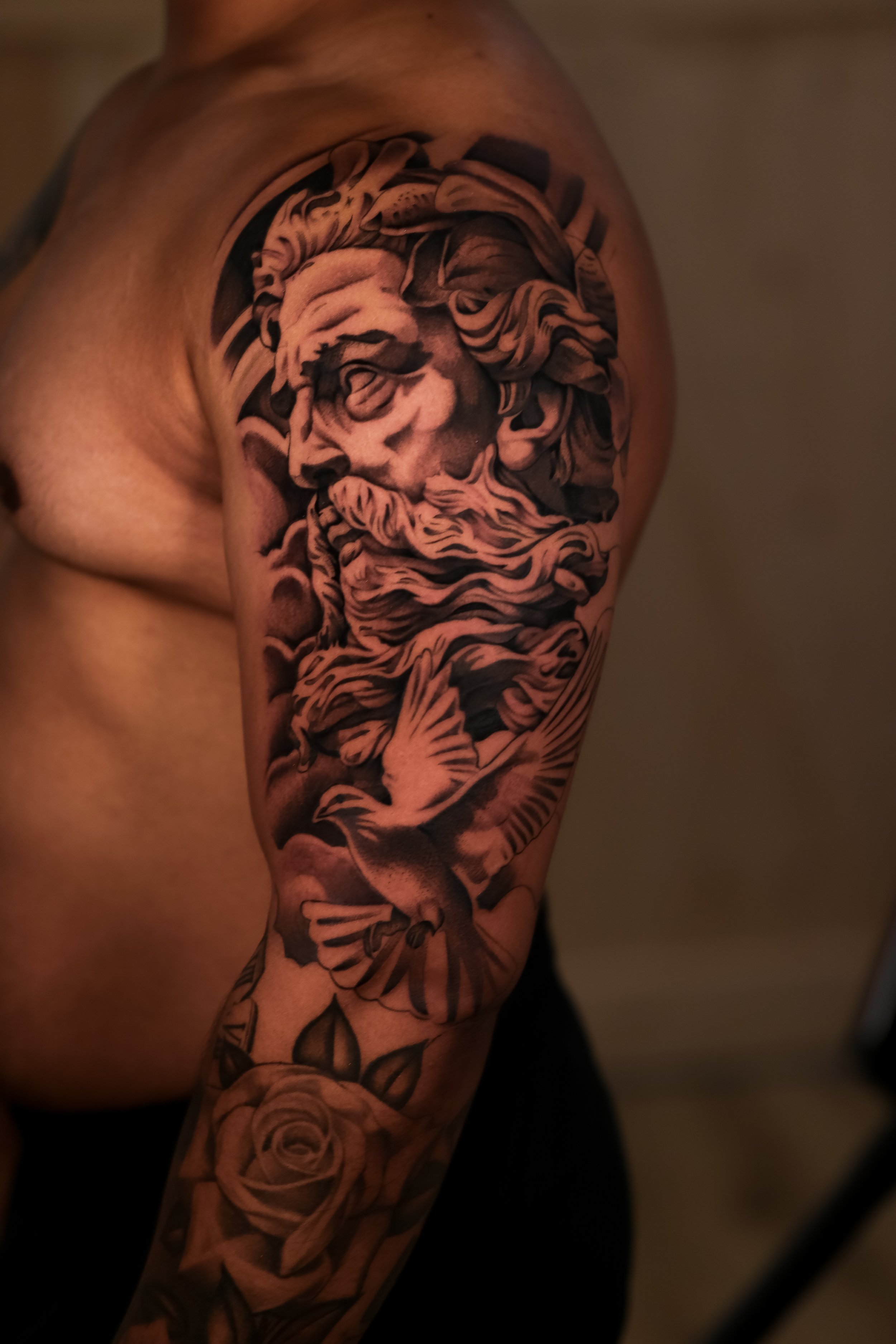 Tattoo of a detailed lion's face and flowing mane on a person's upper arm and shoulder.