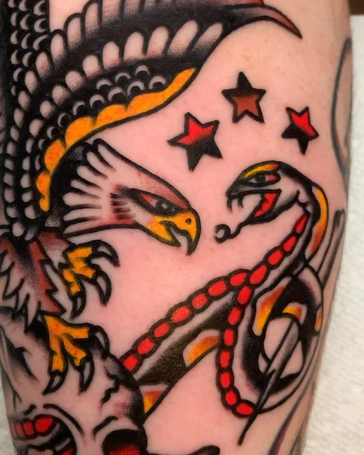 Tattoo of an eagle and a snake facing each other with three red and black stars above them.