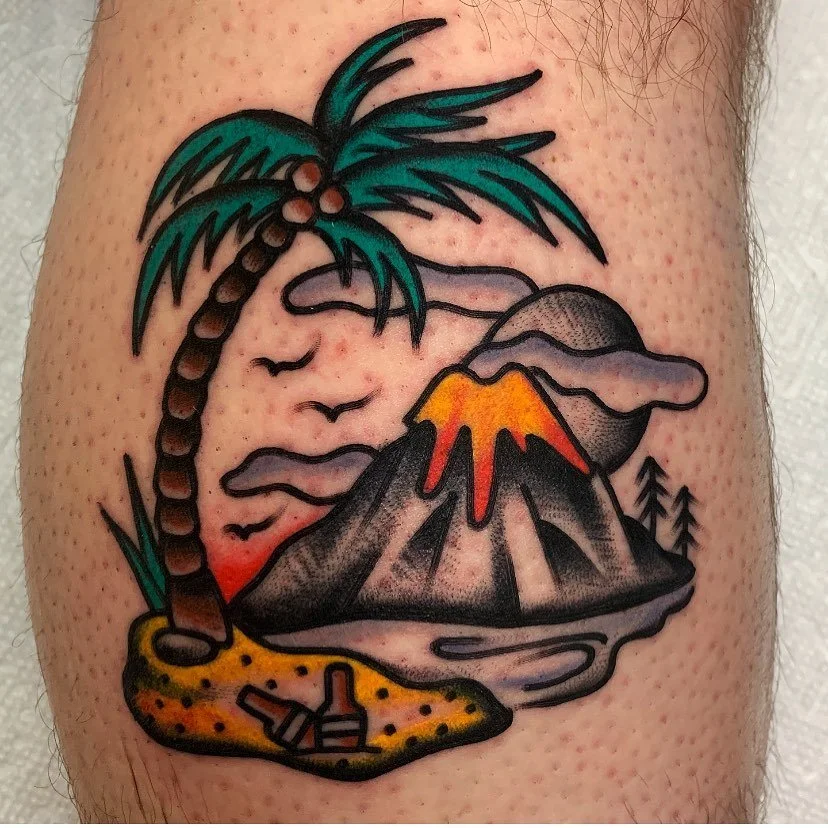 Tattoo of a tropical landscape with a palm tree, volcano erupting with lava, clouds, birds, and water, with a sunset in the background.