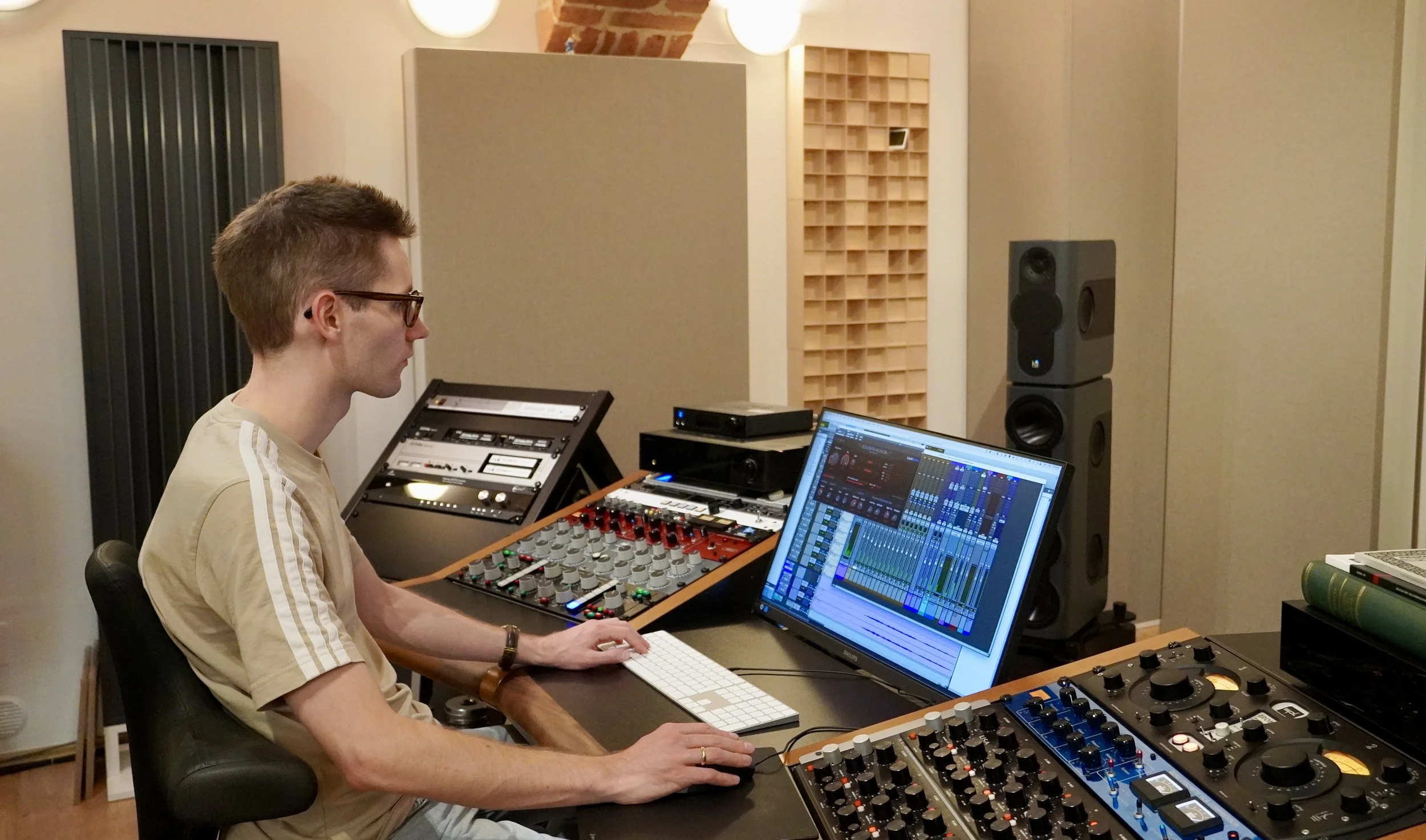 Tonmeister Malte Waag arbeitet in einem Tonstudio mit Musikproduktionssoftware und professioneller Audiotechnik an einer Dolby Atmos Mischung.