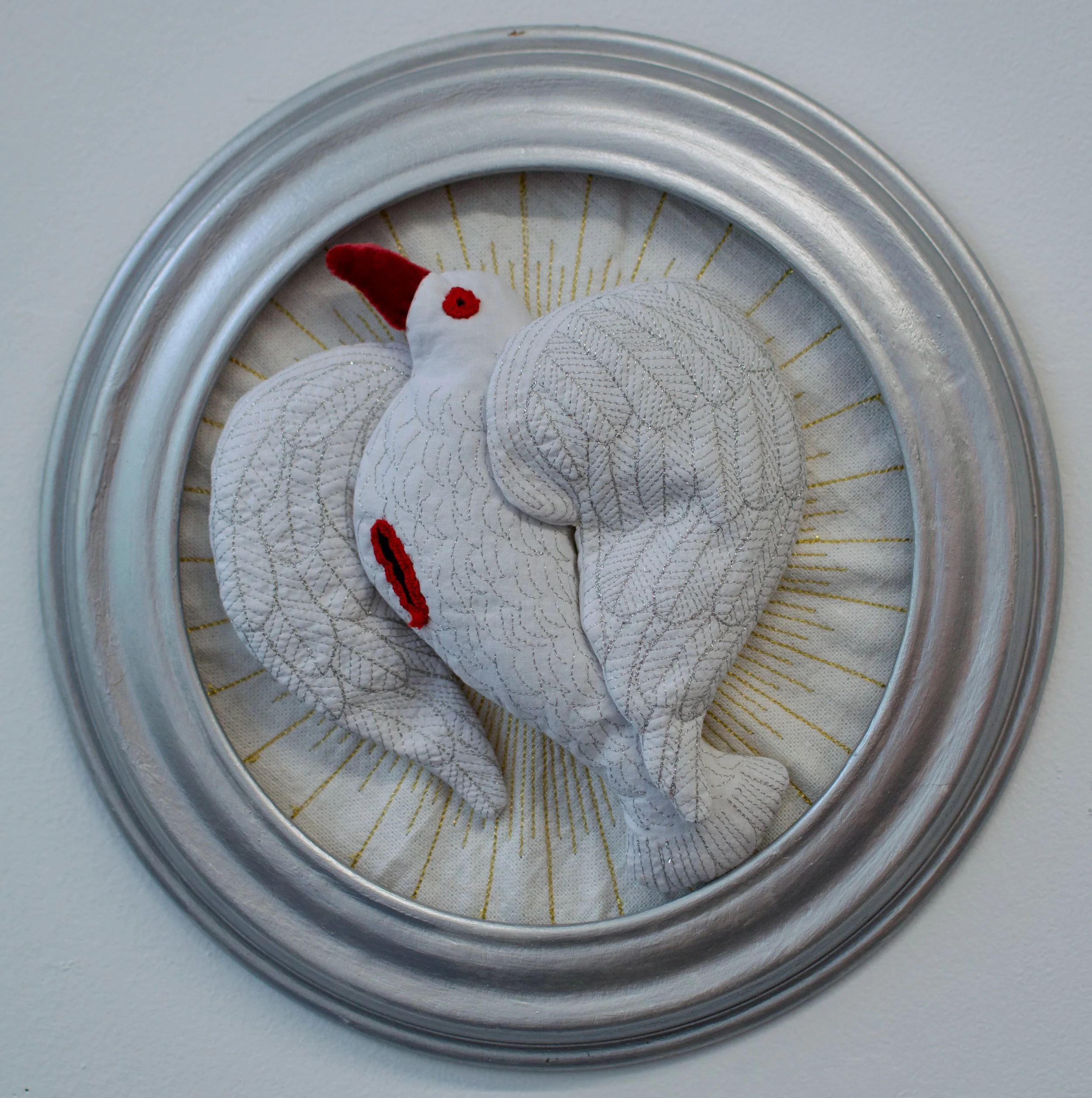 "Assaulted Holy Spirit" 2026, 11" diameter. Recycled fabric, polyfill on recycled frame