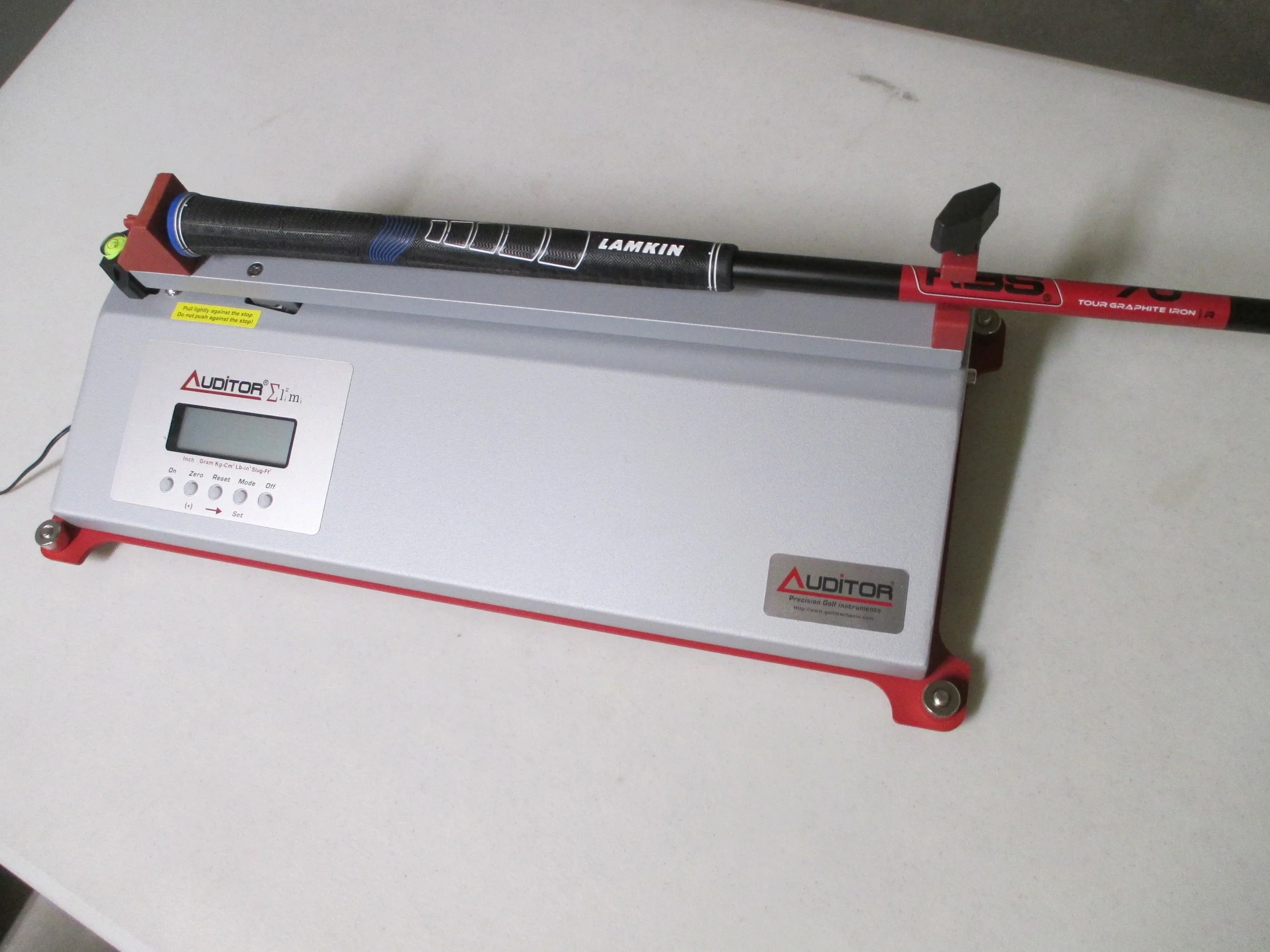 Golf club MOI analyzer measuring a Lamkin-gripped club with a graphite shaft