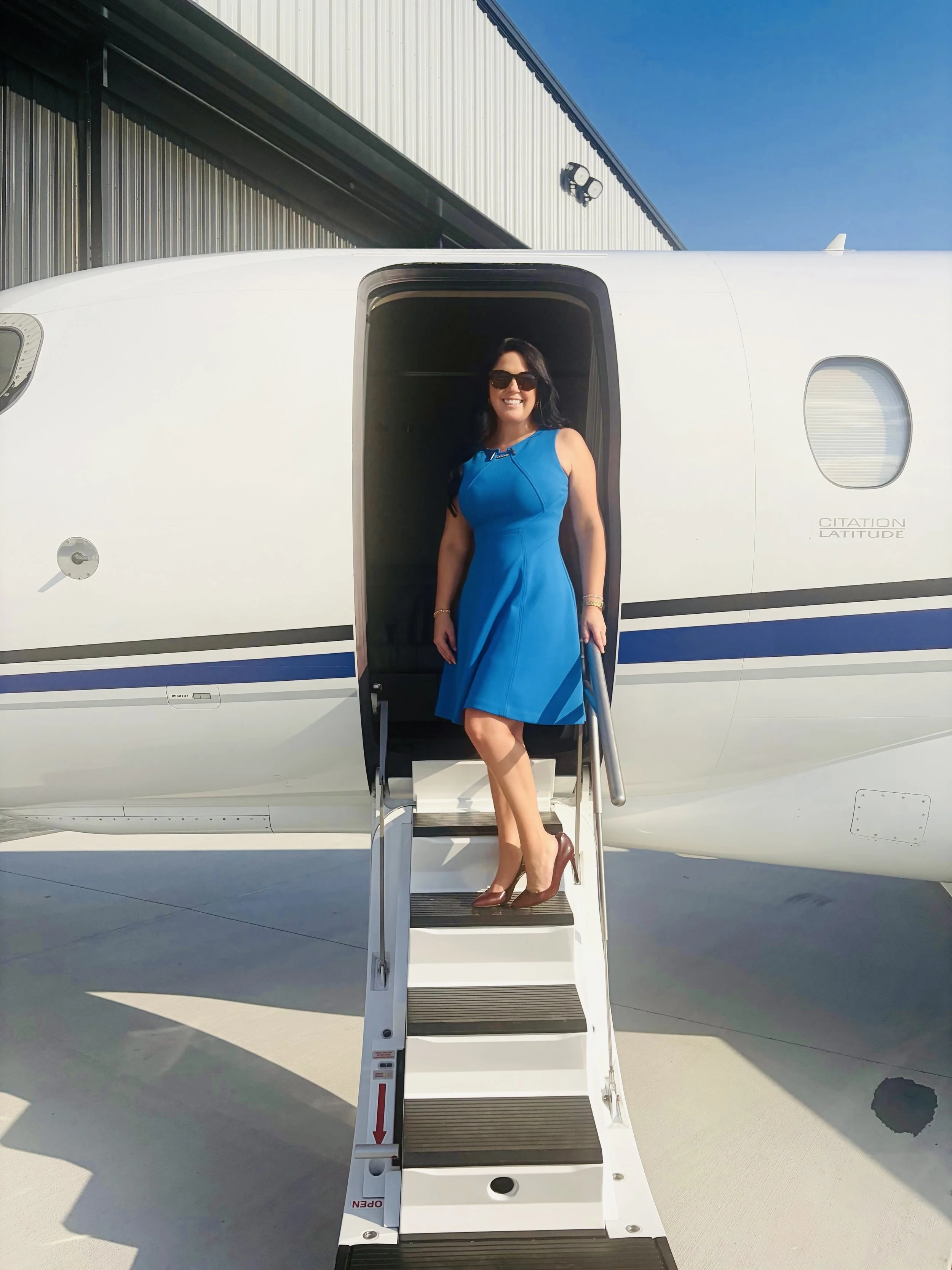 Jenny Ann Urban standing outside a private jet at an aviation event in Tennessee.