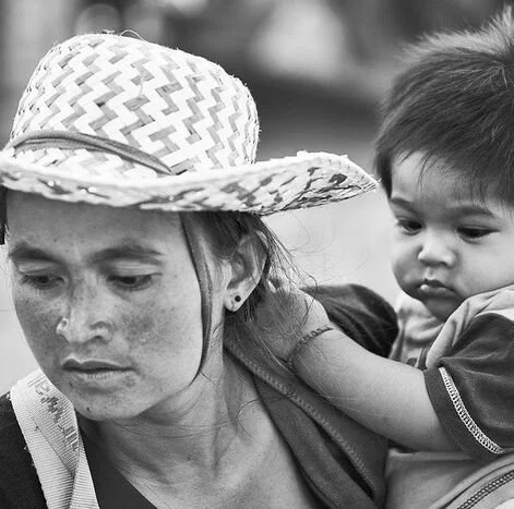 Black and White Close-Up Portrait of Mother Wearing Woven Straw Hat Carrying Toddler Child