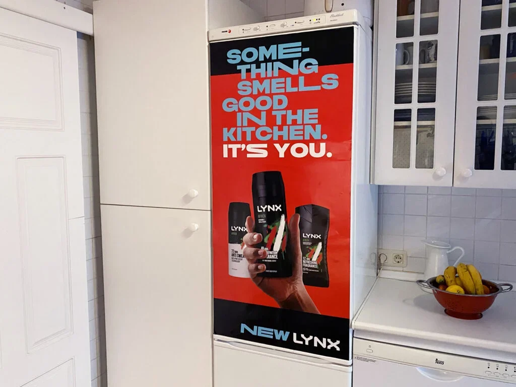 Un anuncio en la nevera que dice que algo huele bien en la cocina, y que tú eres la causa, mostrando productos Lynx.
